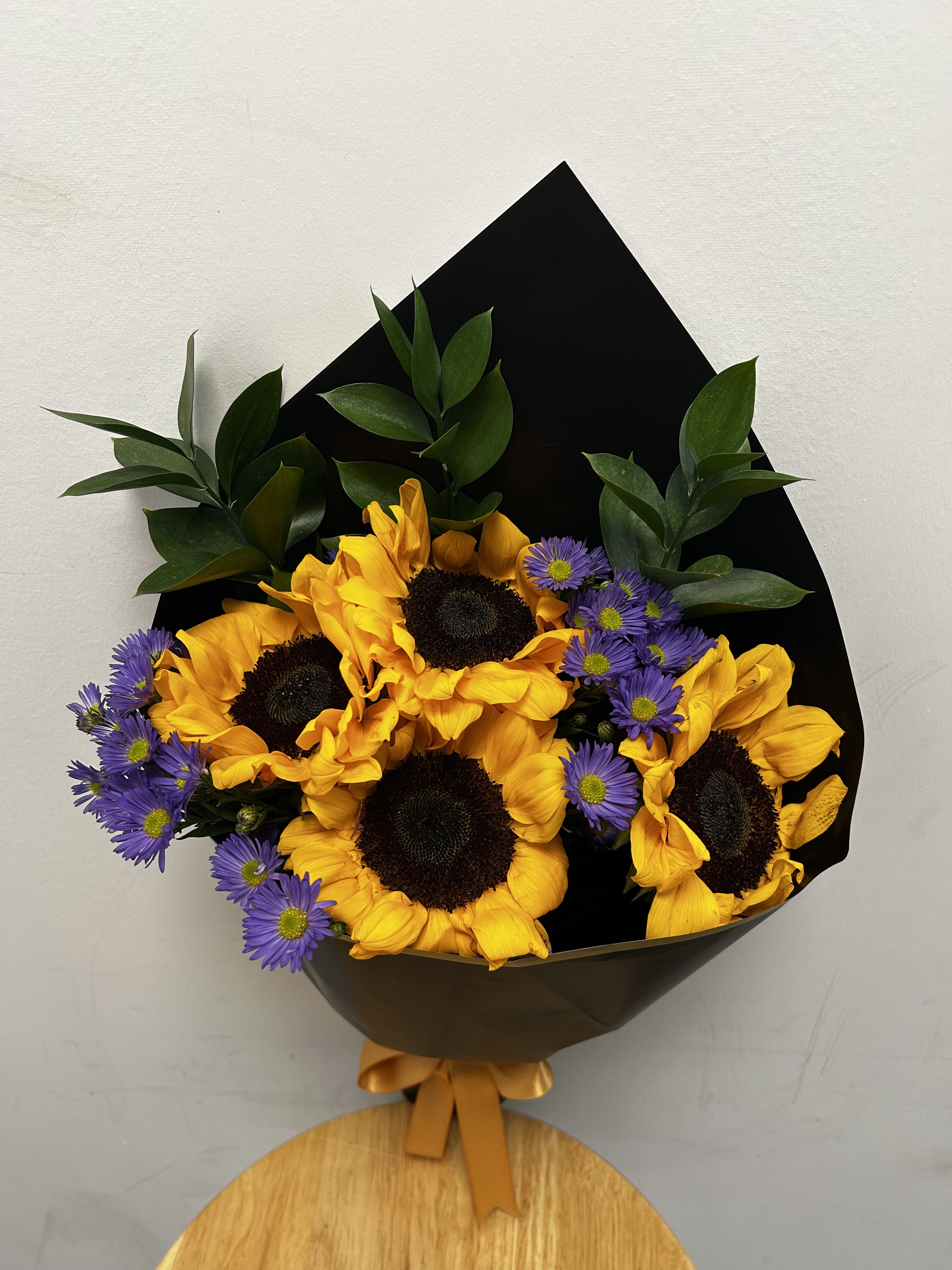 Small Sunflower Bouquet Small Sunflower Bouquet - This arrangement features sunflowers, purple aster, and ruscus.