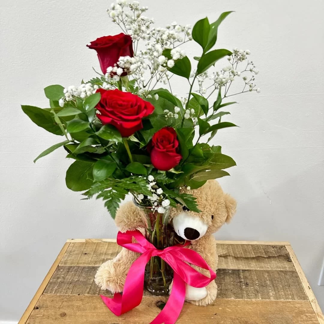 Cuddly Rose Trio - This charming arrangement, Cuddly rose trio, features a trio of vibrant red roses paired with delicate baby’s breath. The small vase is adorned with a bow and lovingly embraced by a cute, cuddly bear, adding a touch of warmth and whimsy to this heartfelt gift.