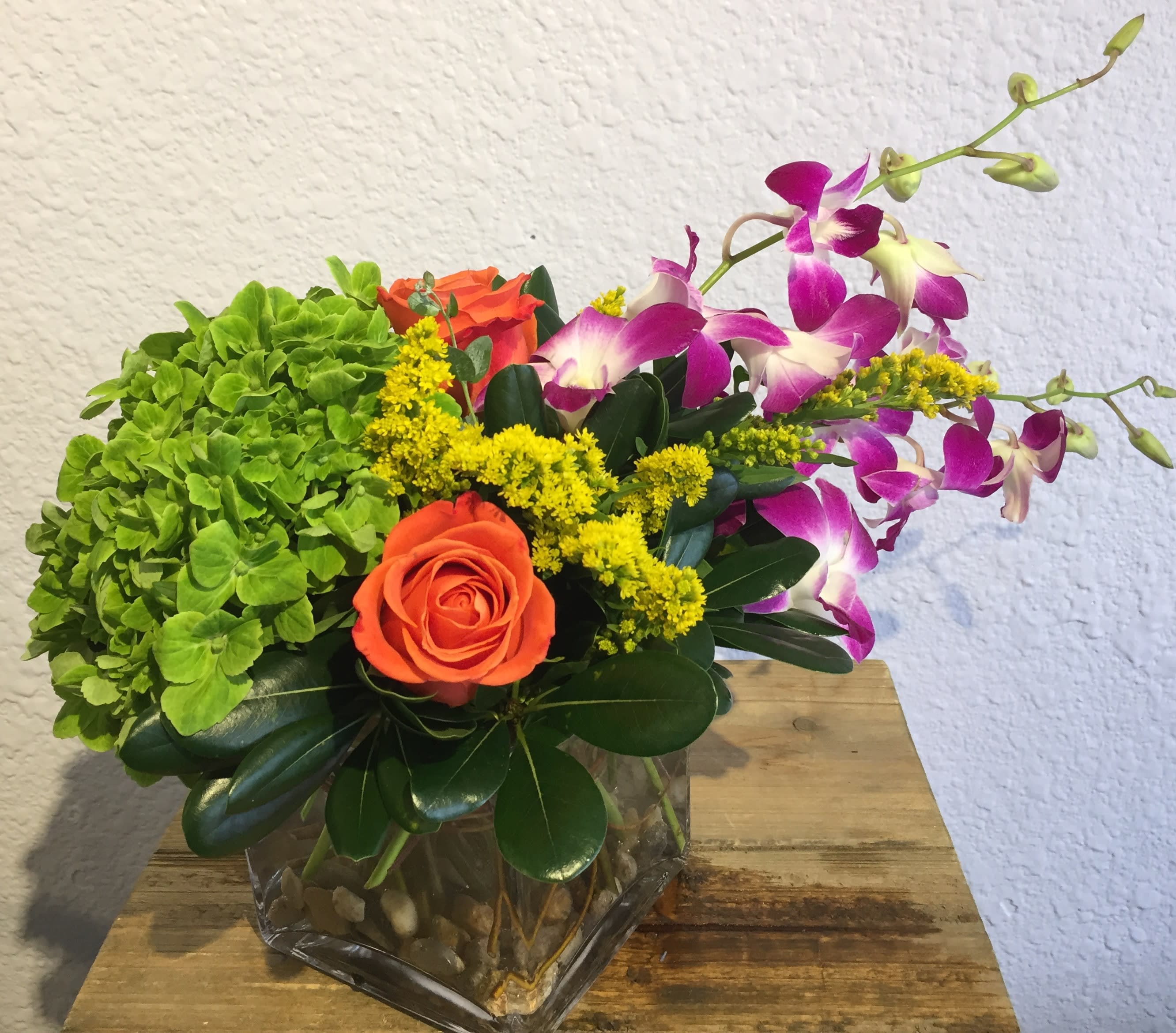 Oh Happy Day! - This bright and cheerful arrangement will turn any day into a happy one! Roses, Dendrobium Orchids and Hydrangea, displayed with bright colors &amp; accents. Your arrangement will be designed in the style shown but flowers and containers may be different from that pictured.