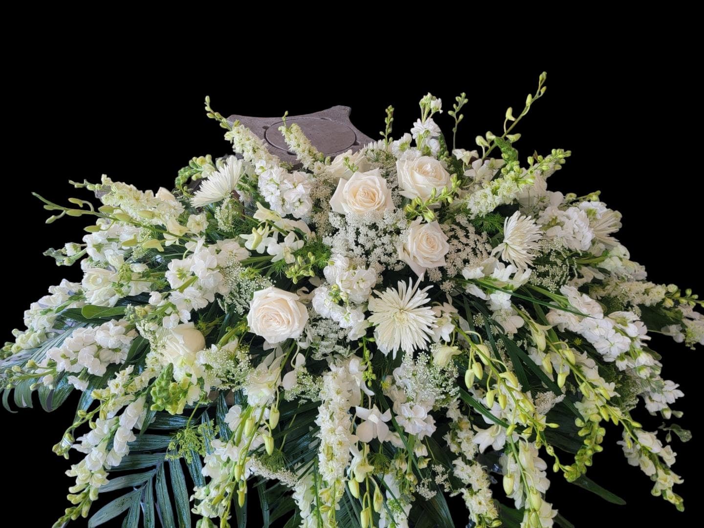 Purest Devotion Casket Spray - Show your purest devotion to your loved one with an all-white casket spray. This half-couch arrangement is suitable for a half-casket. Flower types will vary, based on availability. We customize each piece and strive to make the most beautiful tribute for your family member. Deluxe Casket Spray is Half-Couch with more premium flowers added. Full-Couch Casket Spray, suitable for a closed casket is Premium.