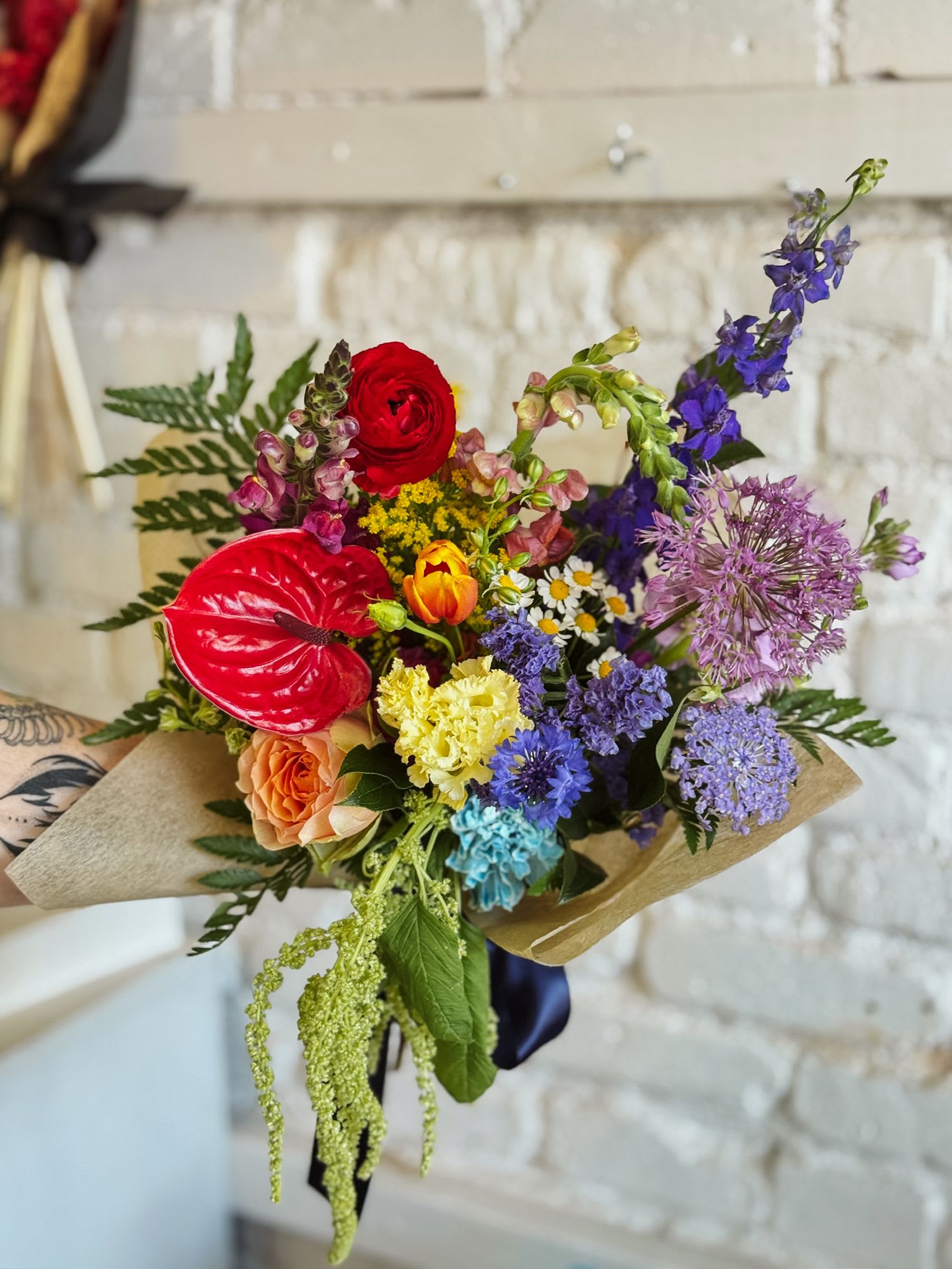 Blooming with Pride - Celebrate love in all its forms with our Blooming with Pride bouquet — a radiant arrangement inspired by the iconic rainbow of the LGBTQIA+ flag. Showcasing all colors of the rainbow, this bouquet is a joyful tribute to diversity, unity, and self-expression. Designed to uplift and inspire, it's perfect for gifting to a loved one or celebrating your own beautiful identity this Pride Month. This product is a hand-tied bouquet. Want it in a vase? Add one to make it extra special!