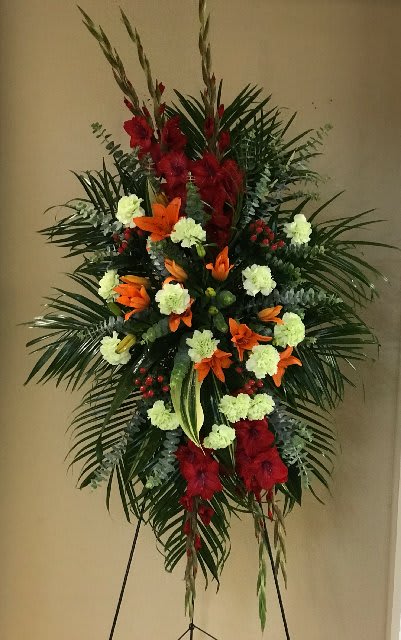 A New Sunrise Spray A New Sunrise Spray - When a loved one has passed, this radiant spray of red and orange flowers will be a reminder of happy times past that will never be forgotten. The stunning arrangement includes orange Asiatic lilies, red gladioli, green carnations, peach hypericum, , accented with assorted greenery.