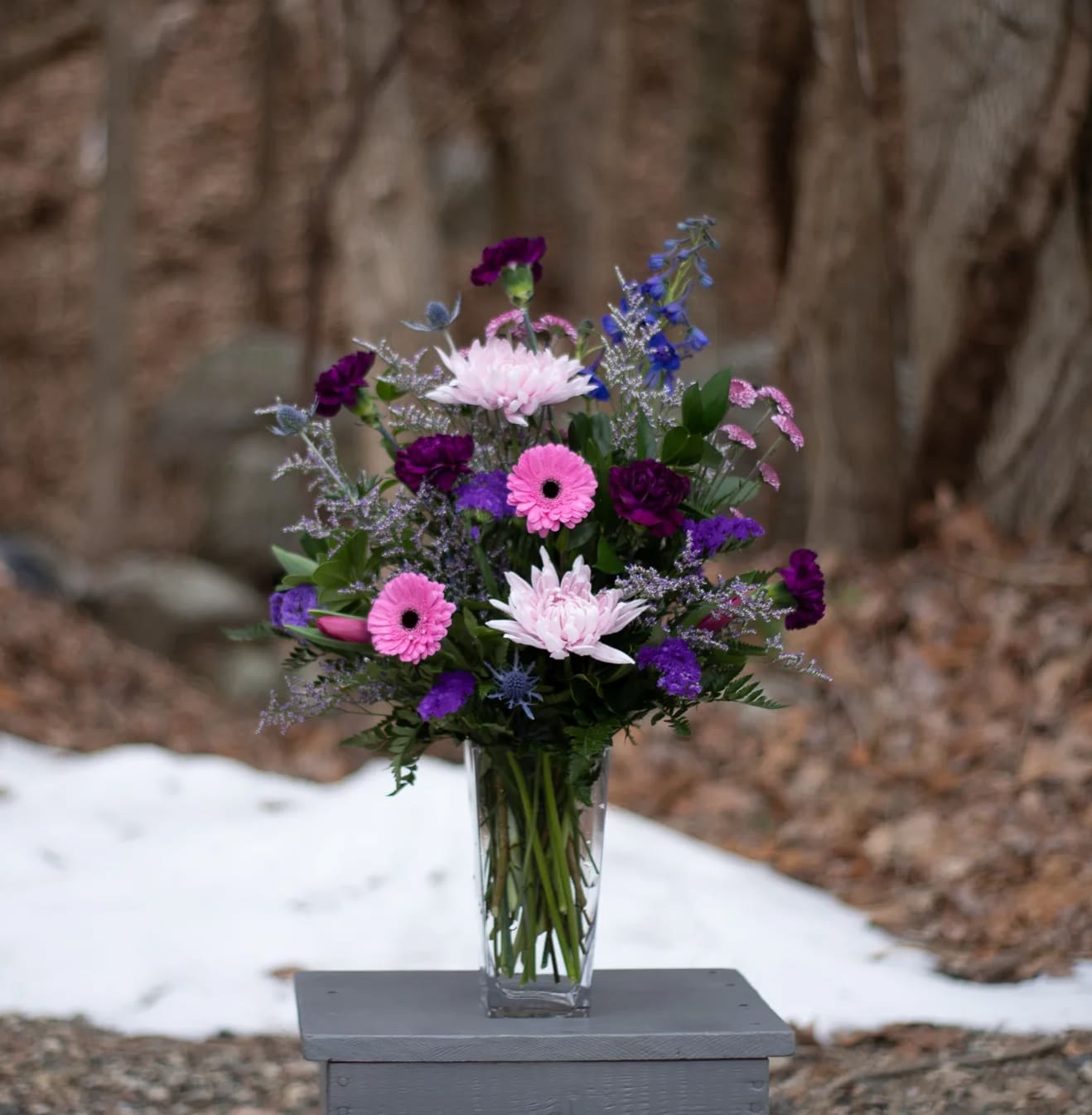 Dreams in Abergine Dreams in Abergine - A playful combination of purple, pink and eggplant blooms. Garden style arranged in a clear glass vase. Deluxe version is shown.