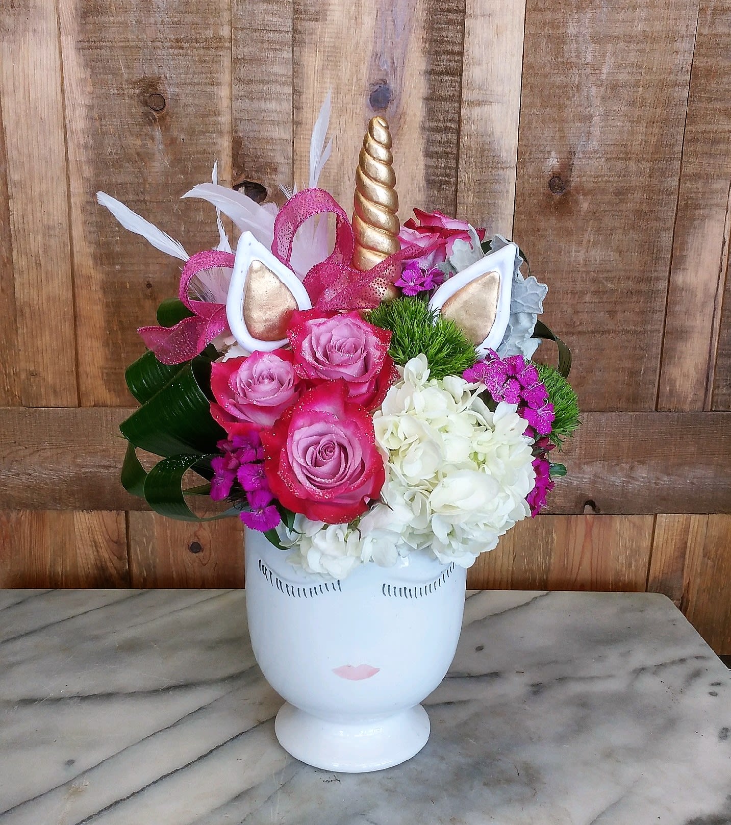 Sparkles The Unicorn Sparkles The Unicorn - Sparkles the Unicorn by Windmill Floral Expressions in Las Vegas is where floristry meets fairy tale—an enchanting bouquet designed to delight dreamers of all ages. Nestled in a whimsical unicorn-themed ceramic vase, this magical arrangement bursts with color, charm, and joyful energy. A playful mix of fuchsia and lavender roses, fluffy white hydrangeas, and vibrant sweet william creates a lush, cheerful palette, while shimmering accent blooms add a touch of sparkle and fantasy. Topped with a golden horn and delicate ears, Sparkles brings imagination to life in the most floral of ways. Perfect for birthdays, children's parties, or anyone who still believes in magic, this one-of-a-kind design adds wonder to any celebration. Available for same-day flower delivery in Las Vegas and Henderson.