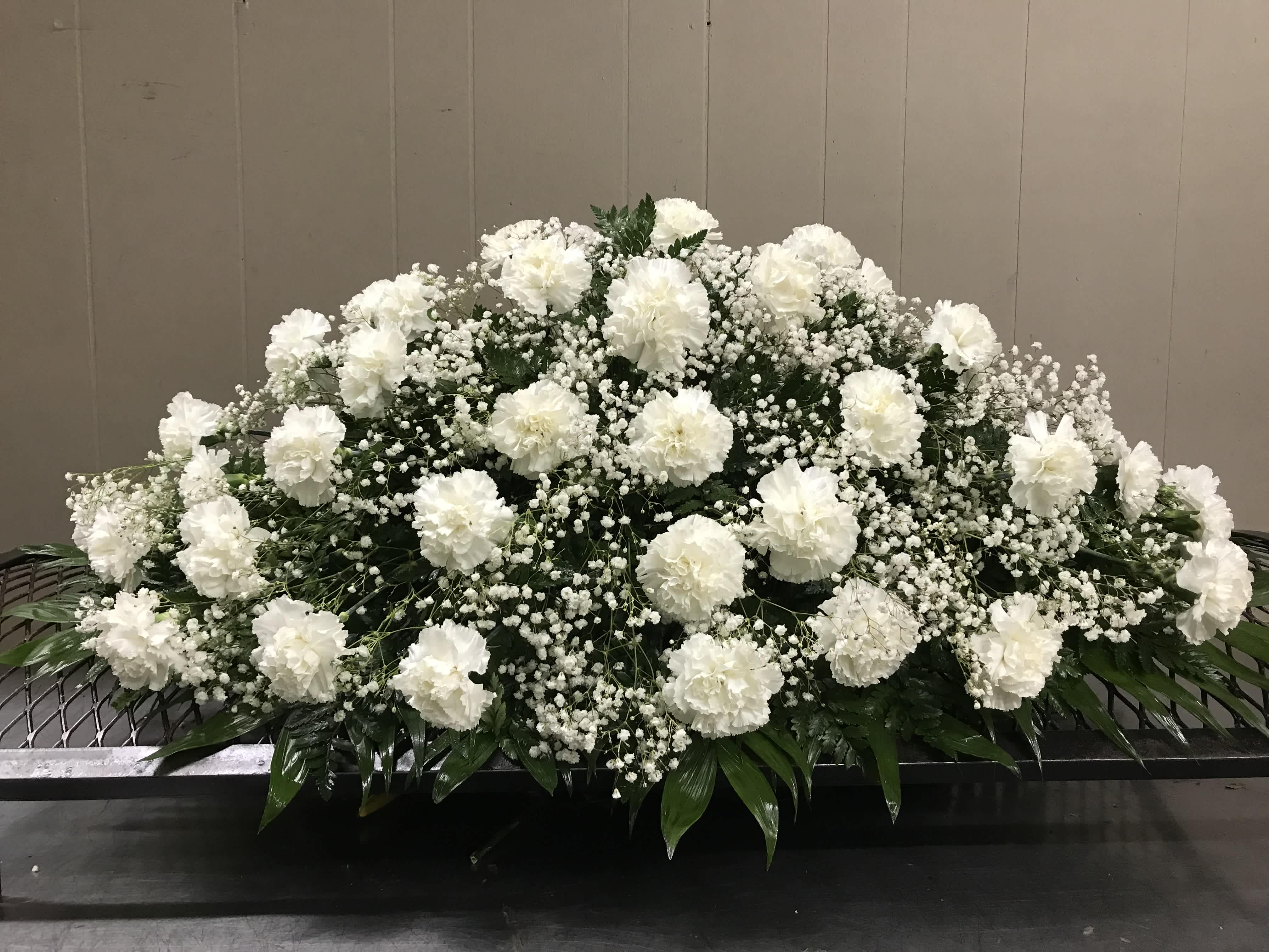 Carnation Casket Spray - A timeless tribute of love and remembrance, this elegant casket spray features fresh carnations in your choice of color — red, white, pink, blue, yellow, and more. Shown here in serene white, this classic arrangement offers a graceful way to honor a loved one with beauty and dignity.