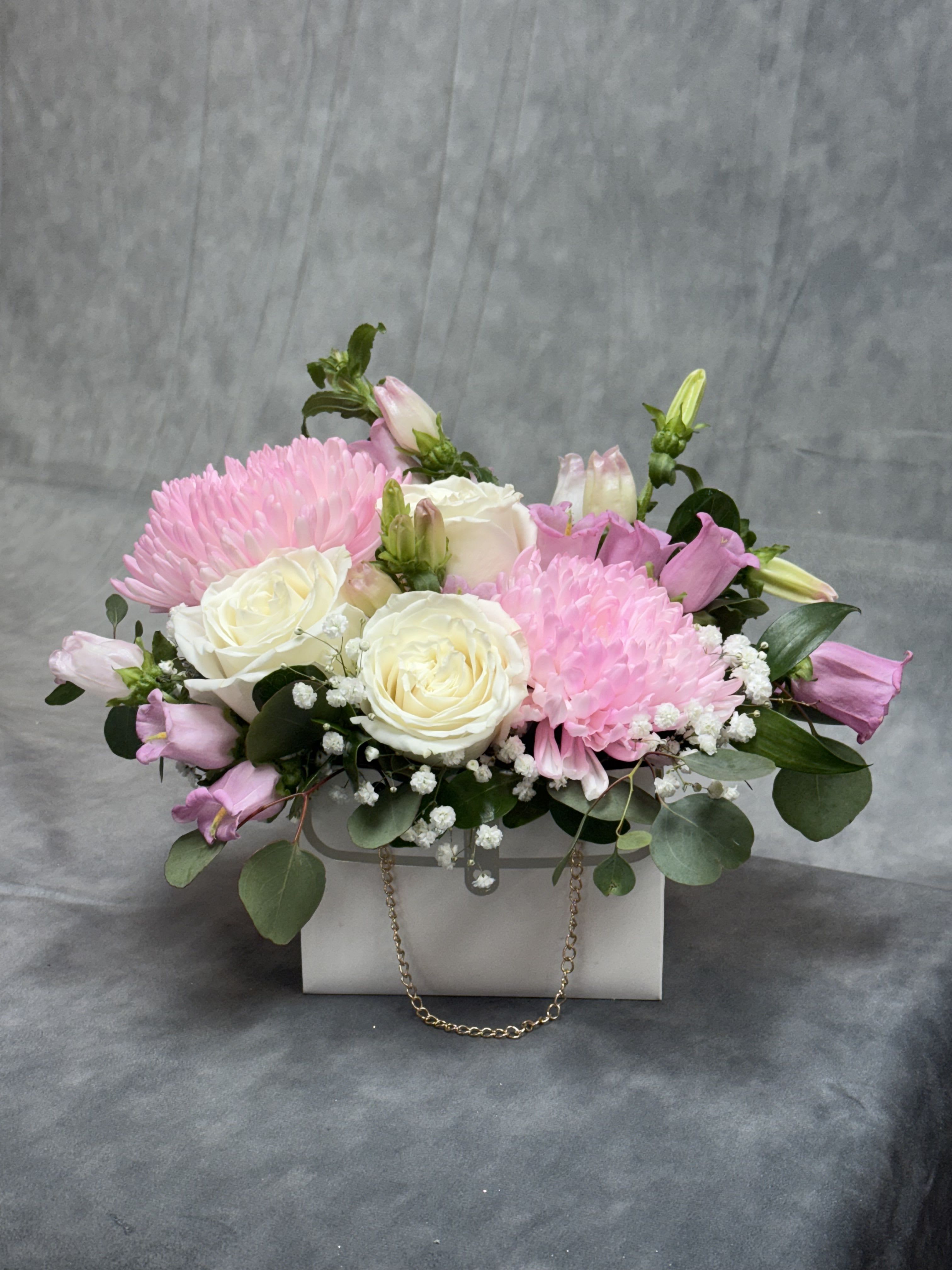 Soft love bag - A stunning bag arrangement with a passionate white roses with pink mum , baby brass and greenery perfect for any occasion.