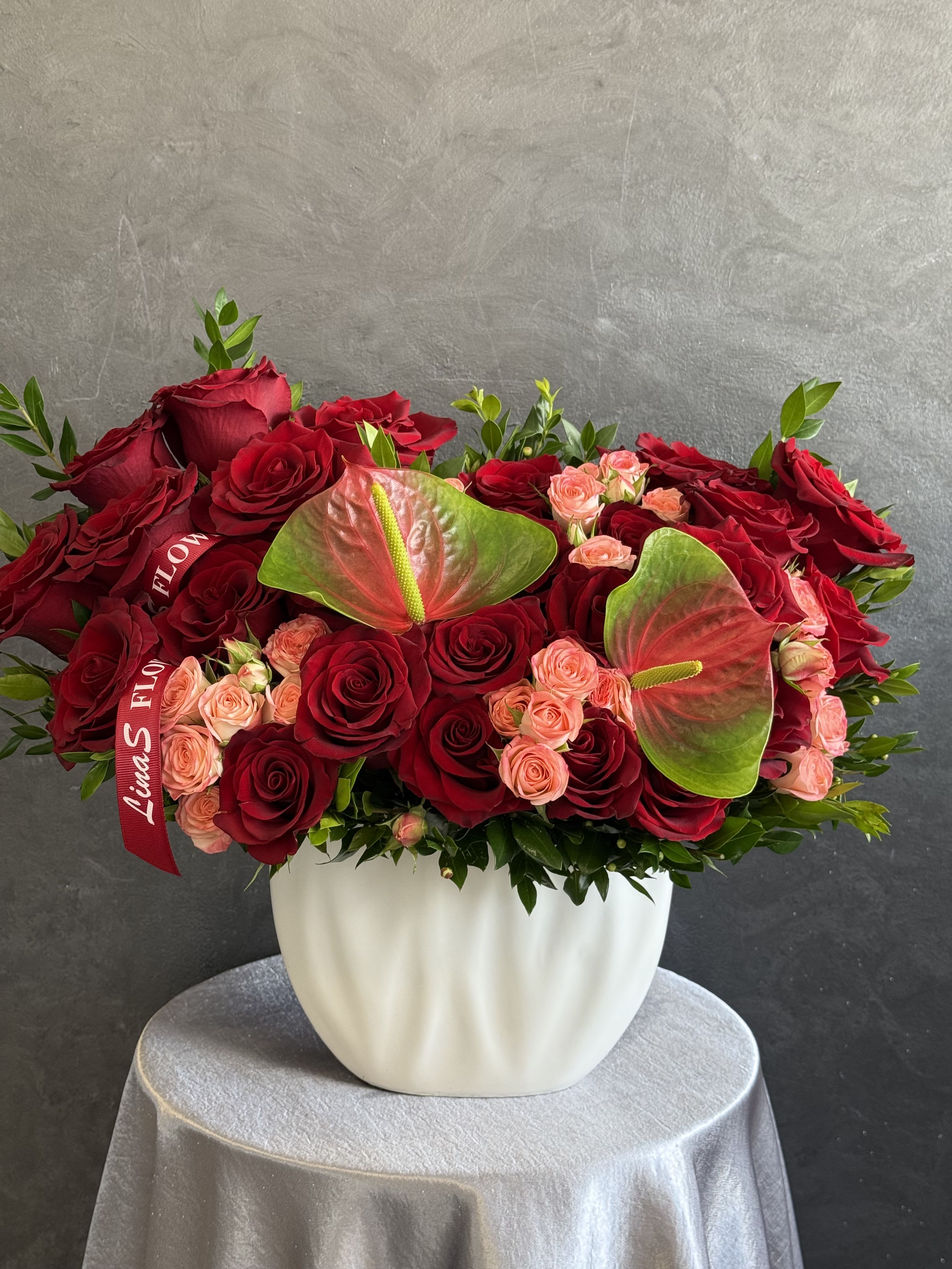 Lama3 Lama3 - A striking arrangement of bold red roses paired with exotic green anthuriums, creating a vibrant and elegant floral display.