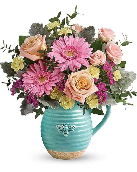 Teleflora's Bee Delighted Bouquet - This delightful bouquet includes peach roses, pink spray roses, pink gerberas, yellow miniature carnations, raspberry sinuata statice, parvifolia eucalyptus, dusty miller, and lemon leaf. Delivered in a Busy Bee pitcher.  Who could help but &quot;bee delighted&quot; by this sweet surprise! Bursting with spring-fresh pink and peach blooms, this charming country-inspired ceramic pitcher is sure to be a favorite food-safe keepsake!