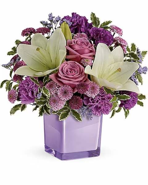 Teleflora's Pleasing Purple Bouquet - These luxurious lavender roses and crisp white lilies are poised to please! Perfectly presented in a stylish cube vase, it's an any-occasion surprise they'll never forget!  Lavender roses, white asiatic lilies, purple carnations, lavender carnations, purple button spray chrysanthemums and lavender button spray chrysanthemums are arranged with lavender limonium and pitta negra. Delivered in a glass cube.