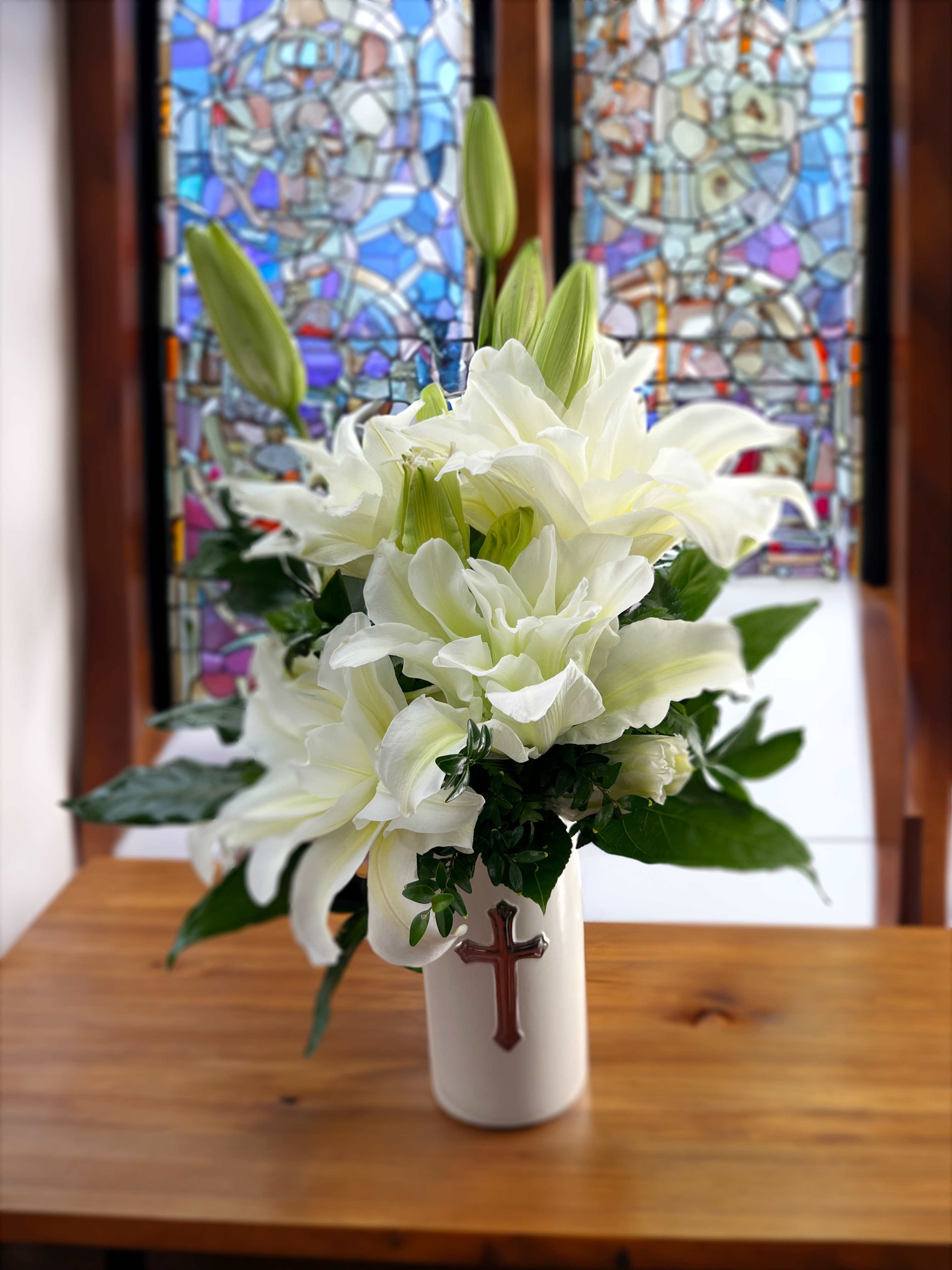 Faithful Cross Vase Faithful Cross Vase - White lilies arranged in a ceramic vase and enhanced by a silver-tone cross.