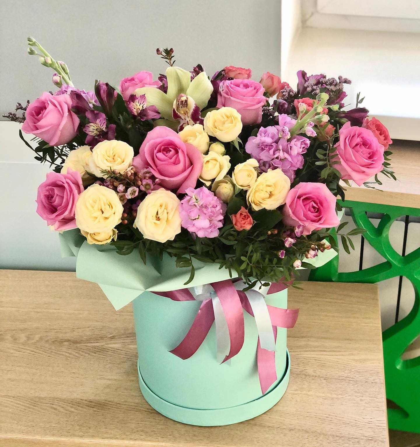 Flower Fantasy Flower Fantasy - This is a beautiful and original box with flowers that can be used as a gift or interior decoration. It consists of pink and yellow roses, mothiola rosea, orchids, limonium, and greenery.