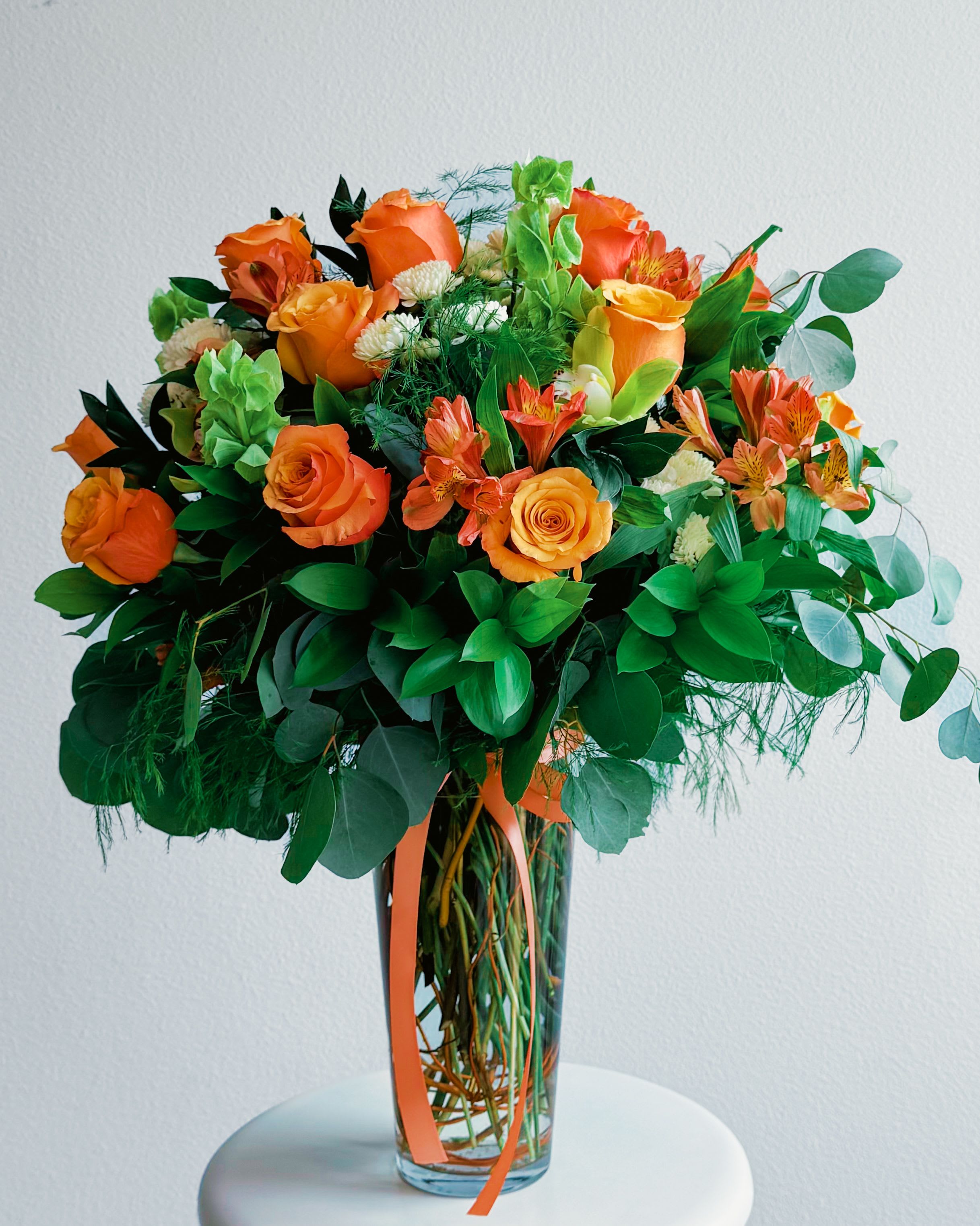 Summer Taste  - Say hello to Summer Taste—a juicy, joy-filled bouquet that looks like it just stepped out of a farmers’ market daydream. With orange roses that pop like a sunset, zesty alstroemeria, creamy accent blooms, and tons of leafy greens, this one smells like fresh starts and feels like sunshine on your skin. Whether you’re gifting a birthday, cheering someone up, or just brightening your own space—this bouquet brings all the warm, happy energy of summer, without the heatwave. Available in Small, Medium, or Large, and styled in a glass vase, hat box, or as a hand-tied bouquet—pick your flavor of sunshine!