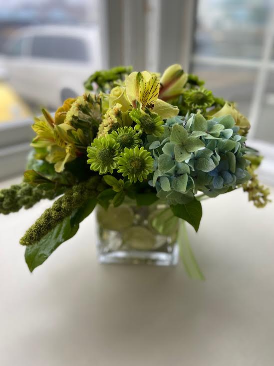 Mojito Mojito - Gorgeous green flowers and foliage gathered in a cube. Between and stems and vase; lime slices are wedged. Designers may substitute flowers and/or container depending on what we have in stock.