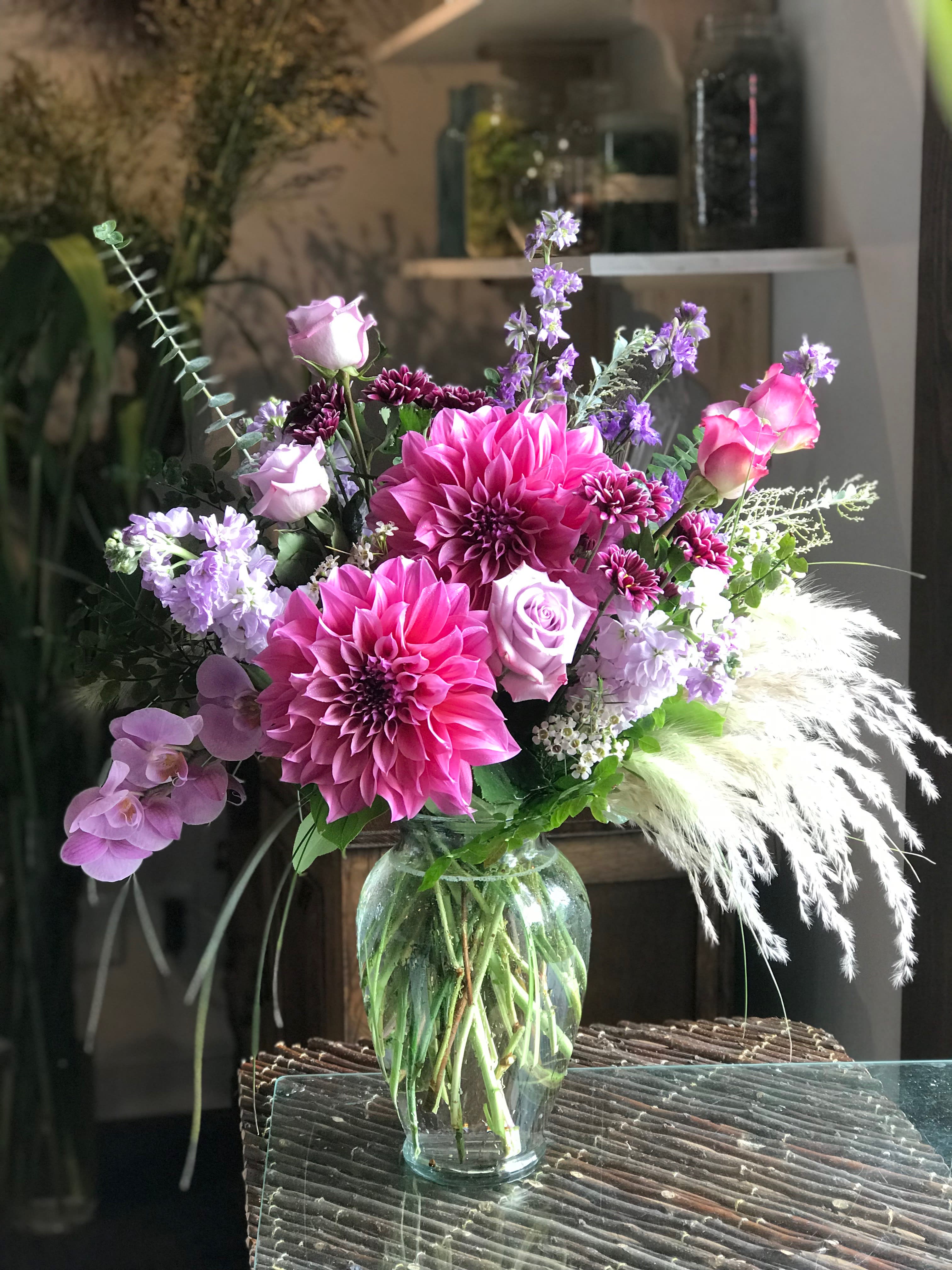 Dazzling Dahlias - Dinner plate dahlias are the star of this show!  Roses, orchids, and pompas grass accent the dahlias.  The example design was created in late summer, so call shop to find out what we have in stock if you're concerned about what exact flowers will be used.  We substitute based on what we have in stock and what's in season.