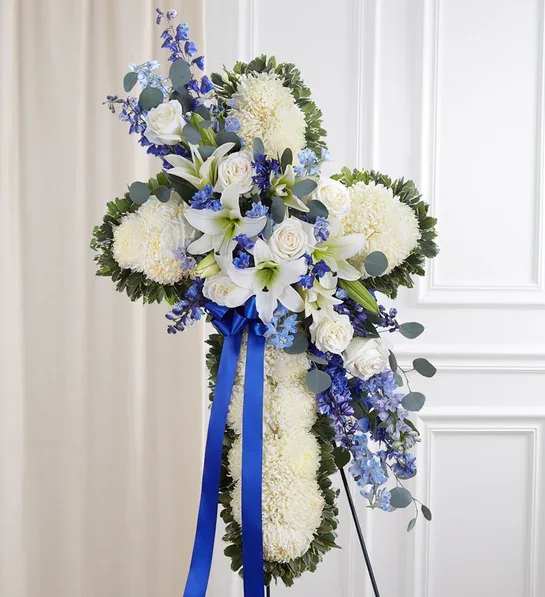 Blue &amp; White Standing Cross - Standing cross arrangement with white football mums, roses and Oriental lilies; blue delphinium; accented with silver dollar eucalyptus, assorted greenery and blue ribbon