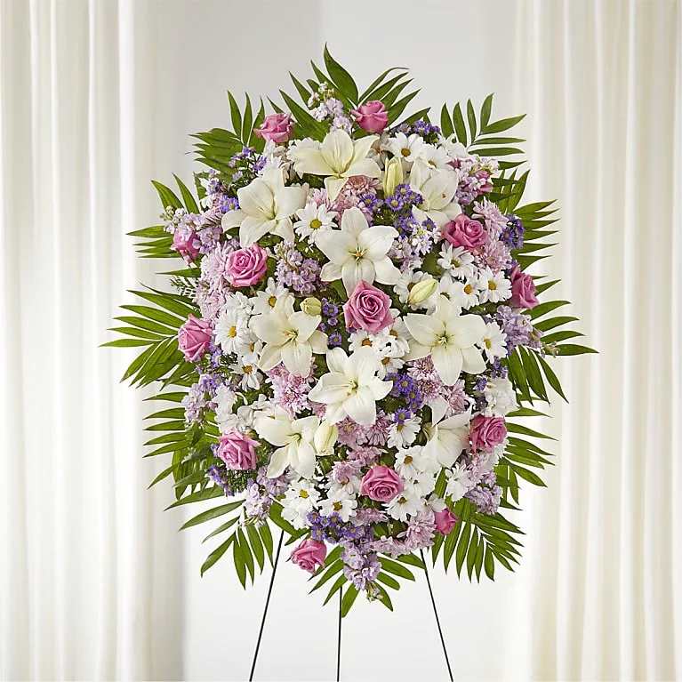 Surrounded by Love Standing Spray - Wrap them in a beautiful hug during a time of need with a warm and inviting standing spray. This spray is artfully designed with white and lavender blooms, making a gorgeous accent to a loved one's service.