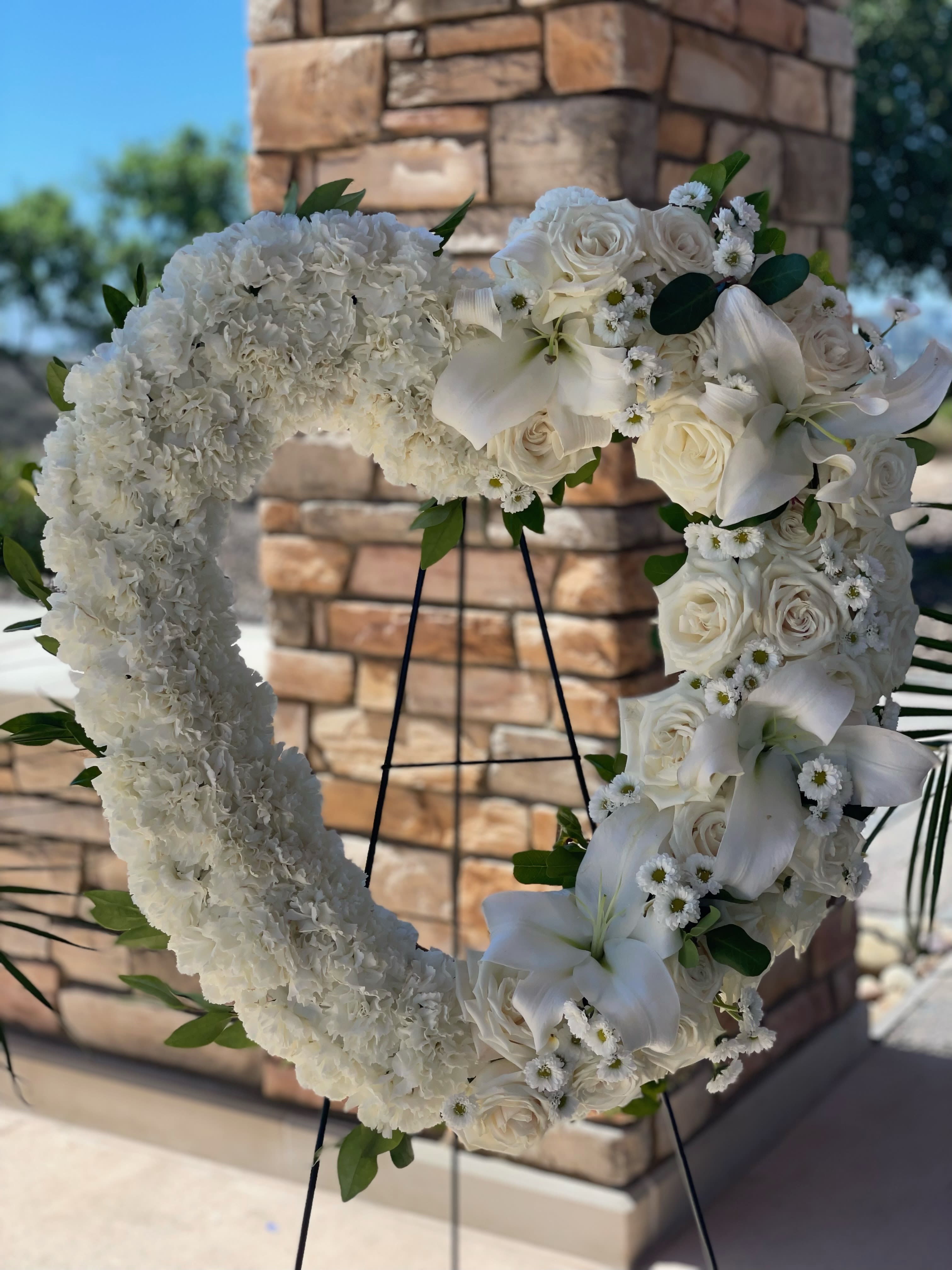 White Serenity Funeral Heart White Serenity Funeral Heart - Elegant white funeral heart adorned with delicate white roses, carnations and lilies- a beautiful tribute of purity and remembrance. Perfect for expressing heartfelt condolences.