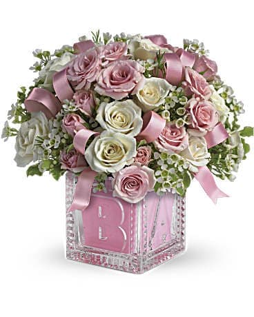 Baby's First Block by Teleflora - Pink - She'll be building block castles soon enough! For now, celebrate her life with this beautiful keepsake baby block. Filled with soft pinks and whites, the glass block can be used later in baby's room and makes a memorable baby girl present. A light pink ribbon weaves through white and pink spray roses in a keepsake glass Baby Block vase. Orientation: All-Around