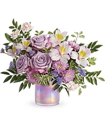 Teleflora's Shimmering Spring Bouquet - Make spring shimmer with this luxurious lavender bouquet, hand-delivered in a keepsake iridescent glass vase she'll treasure forever! Lavender roses, lavender alstroemeria, miniature pink carnations, purple cushion spray chrysanthemums and lavender sinuata statice are arranged with huckleberry and pitta negra. Delivered in Teleflora's Lovely Lilac cylinder. Orientation: All-Around
