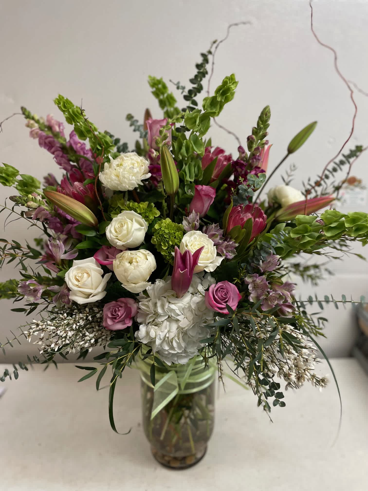 mix of spring flowers mix of spring flowers - tall vase arrangement lavender , pinks , whites , greens