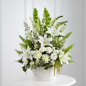 The FTD® In Our Thoughts™  - The FTD® In Our Thoughts™ Arrangement is a symbol of pure peace and caring kindness. White roses, tulips, freesia, Oriental lilies, double lisianthus, monte casino asters, and snapdragons, are beautifully offset by bright green Bells of Ireland, ivy vines, and an assortment of lush greens to create an elegant display that conveys your deepest sympathies for their loss. Arrives in a large round whitewash basket.