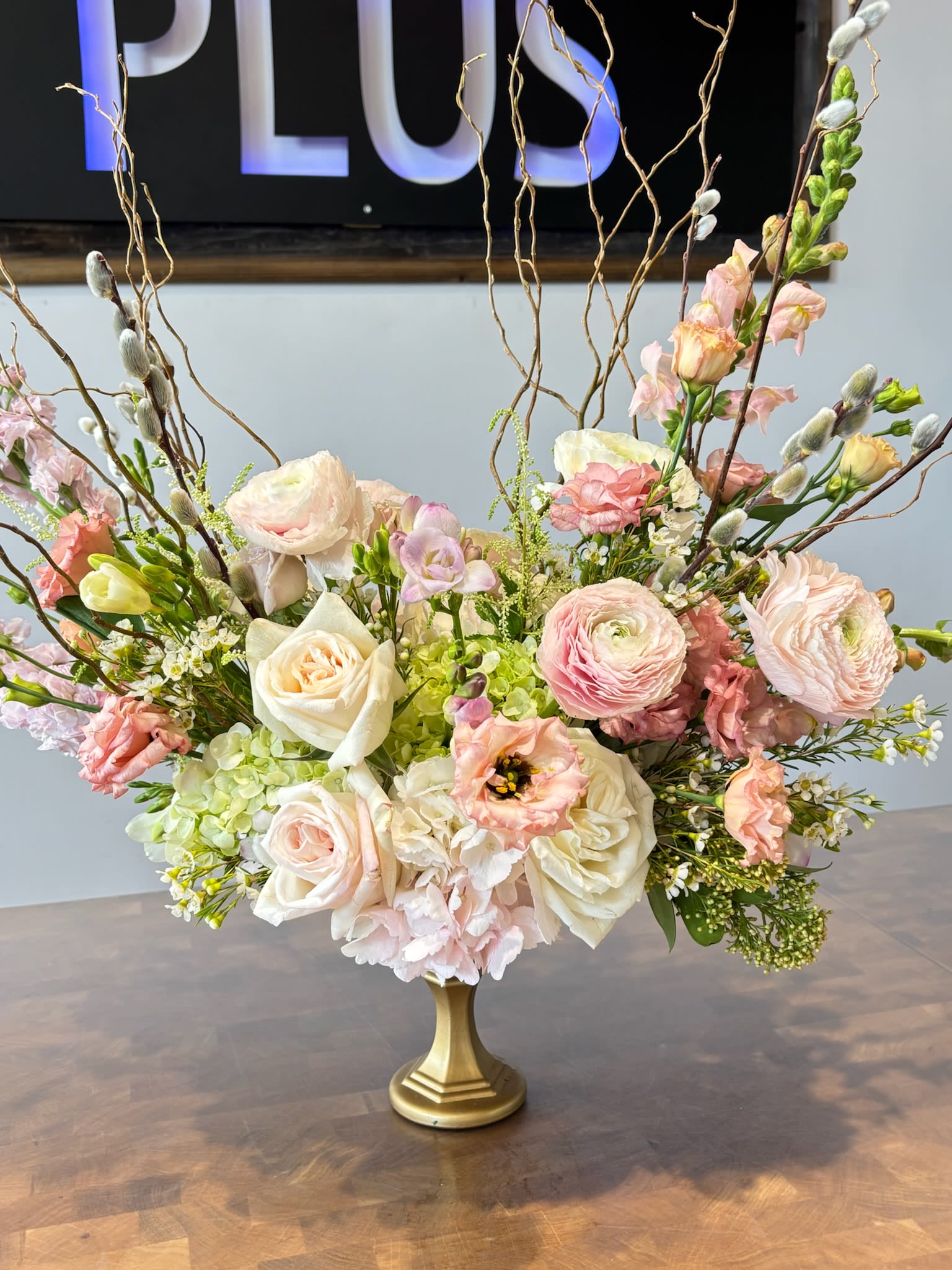 Blushing Fields - An airy, elegant arrangement of blush-toned roses, ranunculus, hydrangeas, and lisianthus, accented with fresh freesia and whimsical pussy willow branches. Soft, warm, and timeless, it brings a gentle romance and natural beauty to any space.