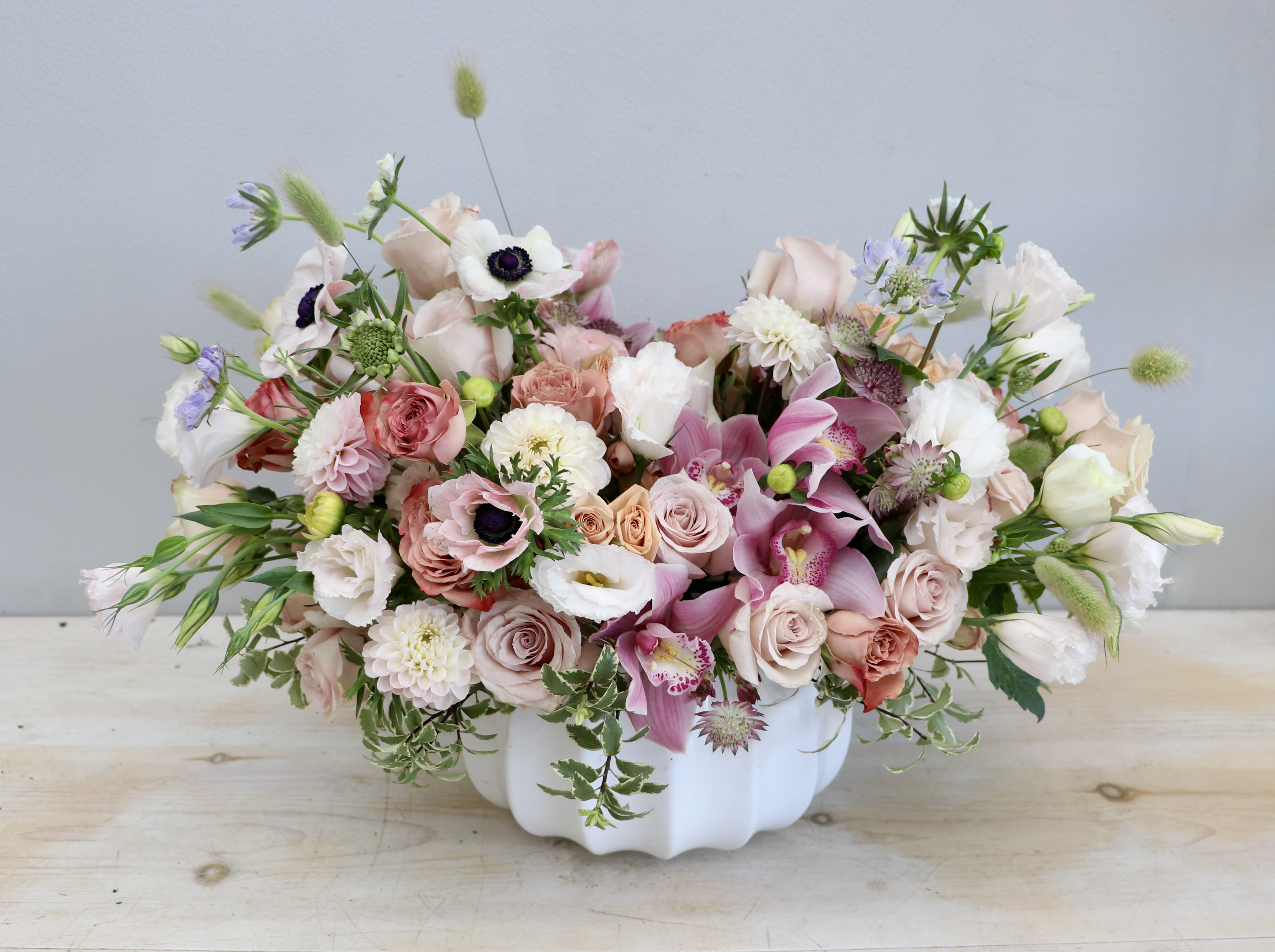 Pastel Dreams - My Glendale Florist - This arrangement is made with a variety of gorgeous flowers including pale dusty pink roses, dahlias, lisianthus anemone, and cymbidium orchids. 