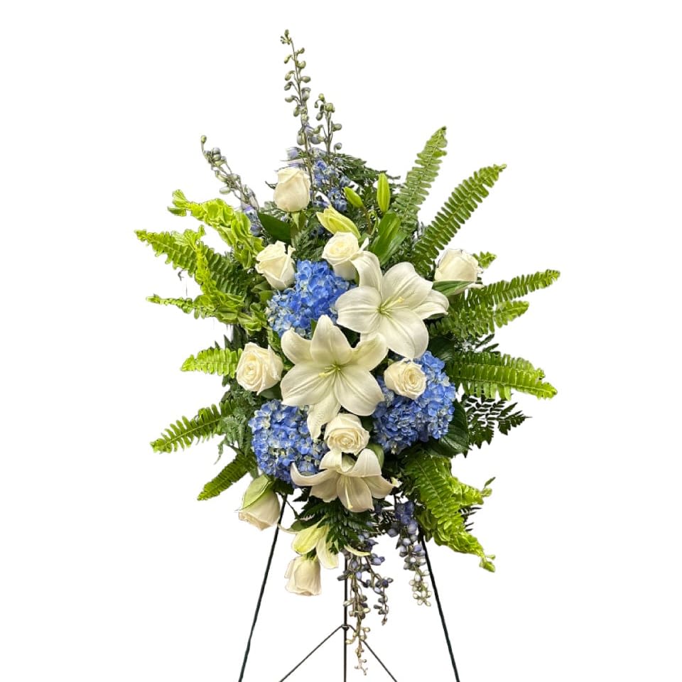 Heavenly Embrace Spray - Heavenly Embrace is a graceful sympathy spray featuring soft, elegant blooms in soothing shades of blue, white and ivory. Symbolizing peace, love, and the gentle embrace of eternal rest, this arrangement offers comfort and heartfelt condolences to those mourning a cherished soul.