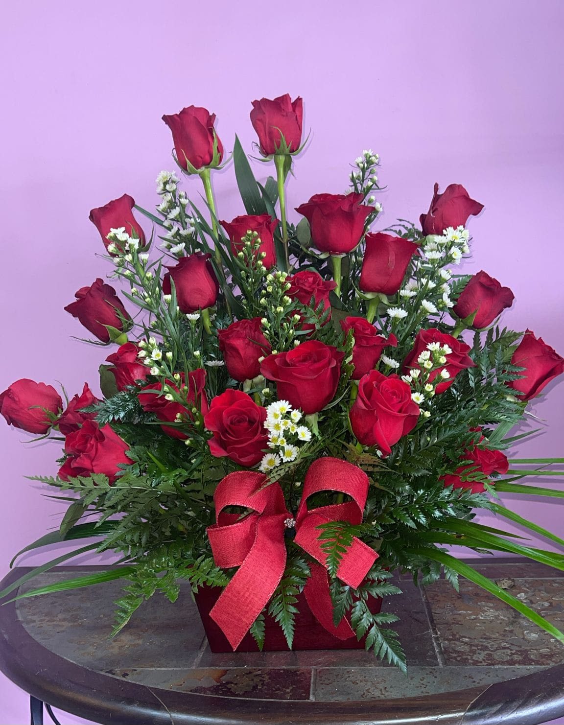 Loving Expression - Express your love with this arrangement of 12 red roses, baby breath some greenery in a red container with red ribbon. 