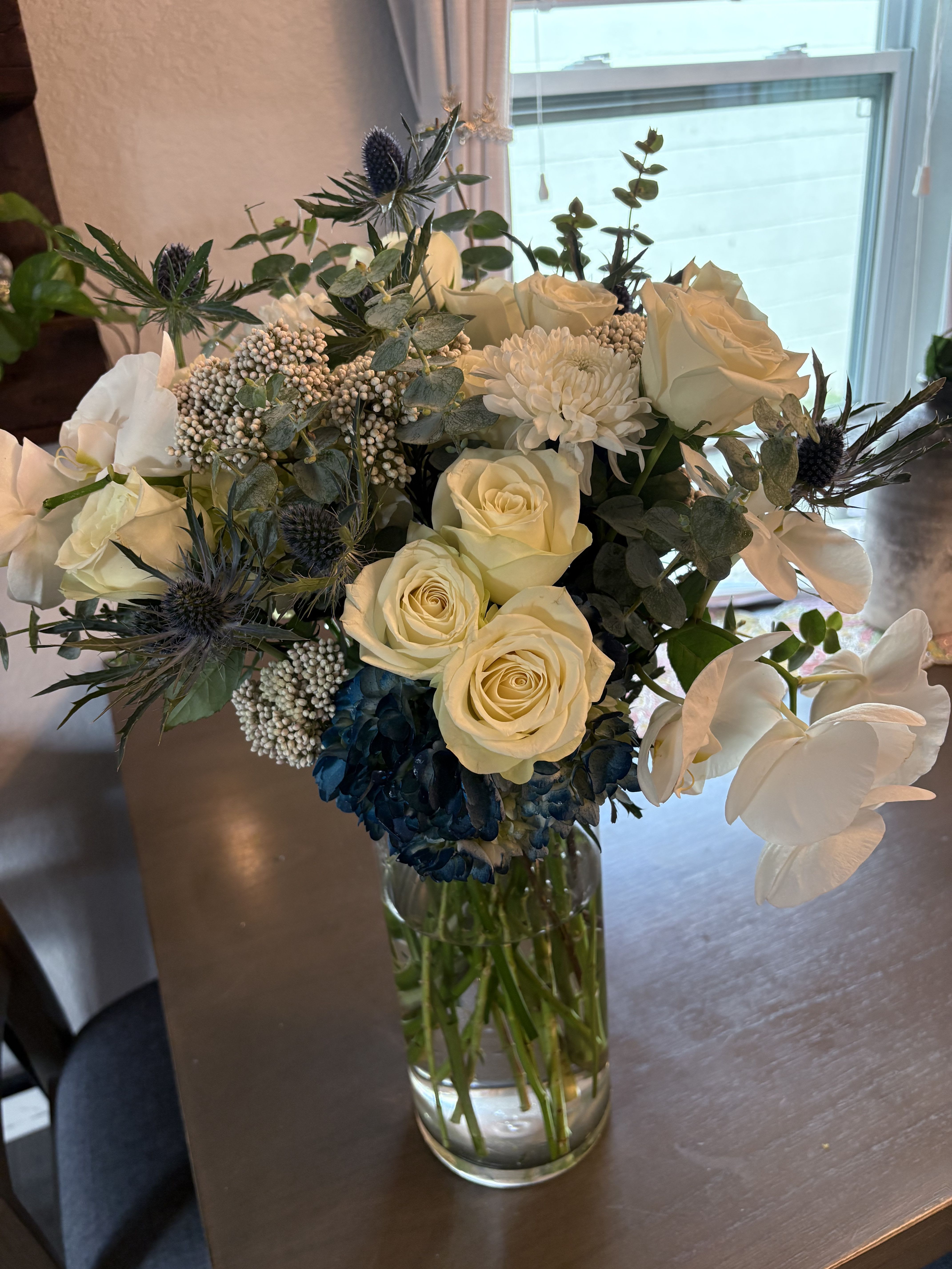 Royal Blue Elegance Royal Blue Elegance - This exquisite floral arrangement combines the serene beauty of navy blue blooms with the pure sophistication of white flowers. Perfect for any occasion, the rich, deep hues evoke a sense of calm and grace, while the crisp whites add a touch of brightness and contrast. This stunning display brings elegance and charm to any setting
