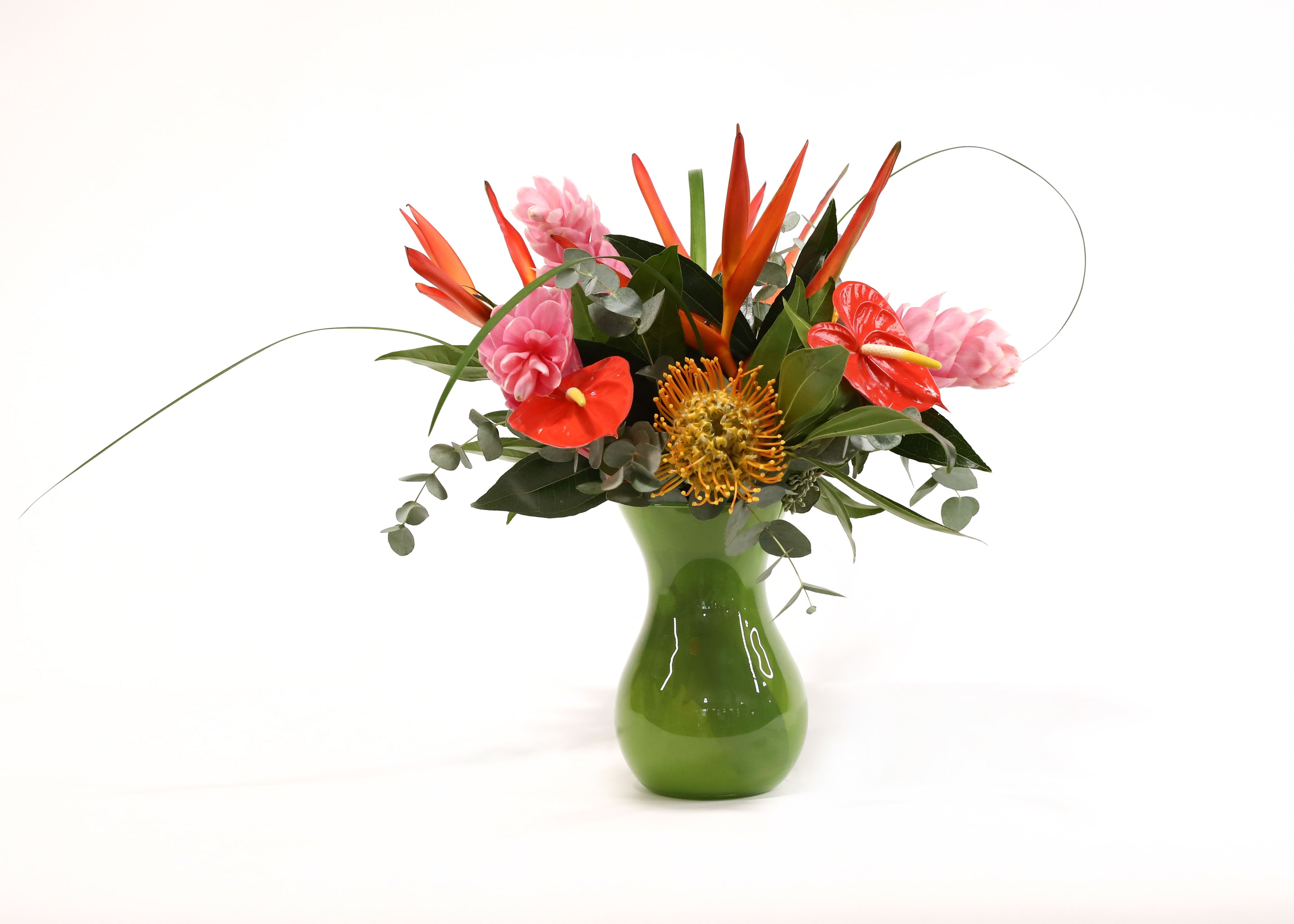 PRETTY PARADISE PRETTY PARADISE - IN THIS GREEN GLASS VASE WE PLACED PIN CUSHIONS, GINGER, ANTHURIUMS, PARAKEETS, AND TROPICAL GREENS TO MAKE THESE TROPICAL COLORS POP.
