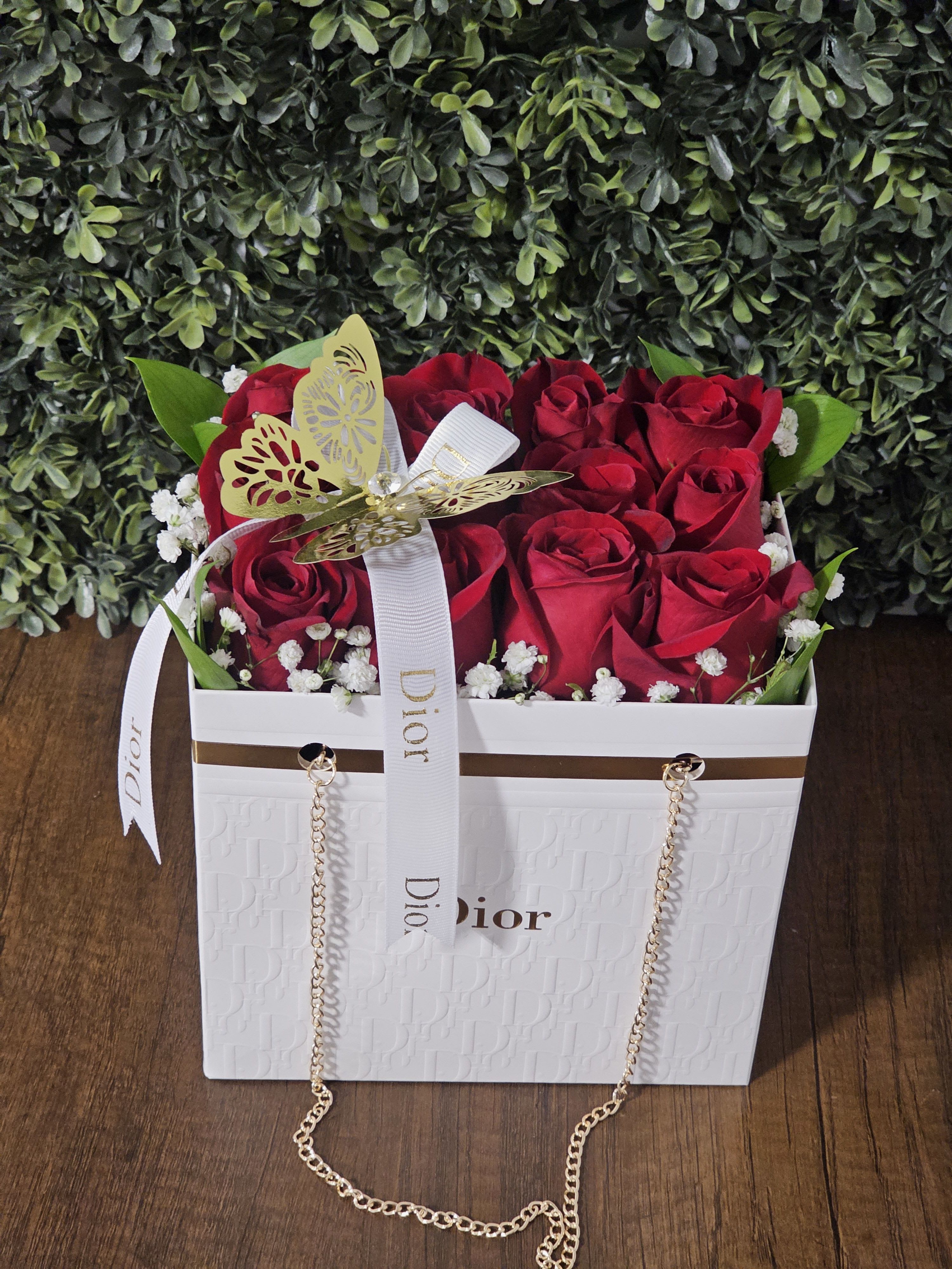 White Dior Bag - White Dior Bag with 12 red roses, baby's breath and greenery, accented with a Dior ribbon and butterfly.
