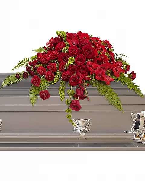 Red Rose Sanctuary Casket Spray - A gorgeous mix of dazzling red flowers will make a grand, yet graceful impression.  Beautiful red roses, spray roses, gerberas, gladioli and carnations along with vibrant green bells of Ireland create a sincere tribute.
