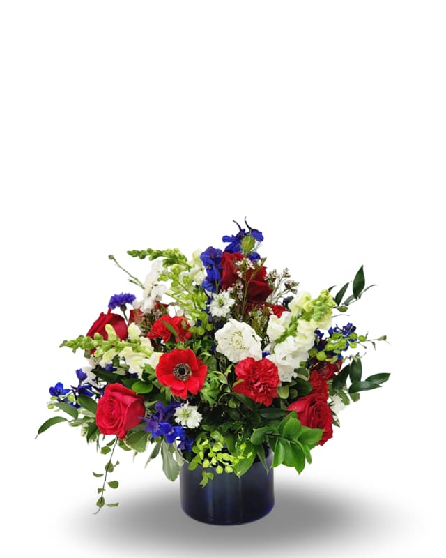 Liberty Bell Liberty Bell - Celebrate in full color with this festive Fourth of July arrangement, bursting with bright red, rich blue, and crisp white blooms. Featuring roses, scabiosa, bella donna, and other seasonal favorites, this arrangement brings patriotic charm and floral flair to your holiday table or celebration. Perfect for adding a pop of color and cheer to your Independence Day festivities.