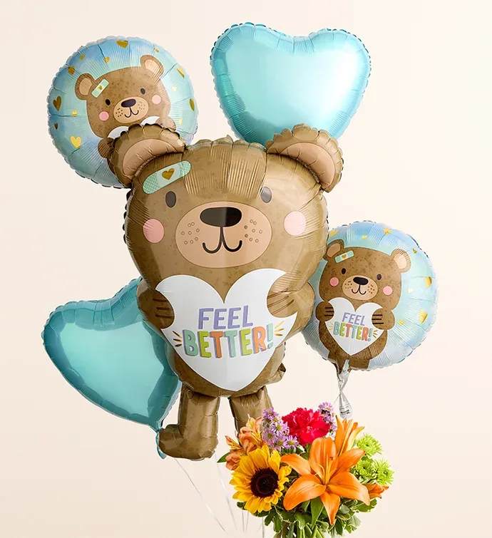 Floral Embrace with Feel Better Bear Balloon Bouquet - All-around arrangement with hot pink roses and carnations; orange Asiatic lilies and Peruvian lilies (alstroemeria); yellow sunflowers; lavender stock; purple monte casino; green Athos poms; accented with assorted greenery Extra-large arrangement measures approximately 16&quot;H x 12&quot;W Large arrangement does not include monte casino; measures approximately 15&quot;H x 11&quot;W Medium arrangement does not include monte casino; measures approximately 13&quot;H x 10&quot;W Small arrangement does not include roses; measures approximately 12&quot;H x 9&quot;W Artistically designed in a clear glass cylinder vase; large vase measures 6&quot;H; medium/small vase measures 5&quot;H