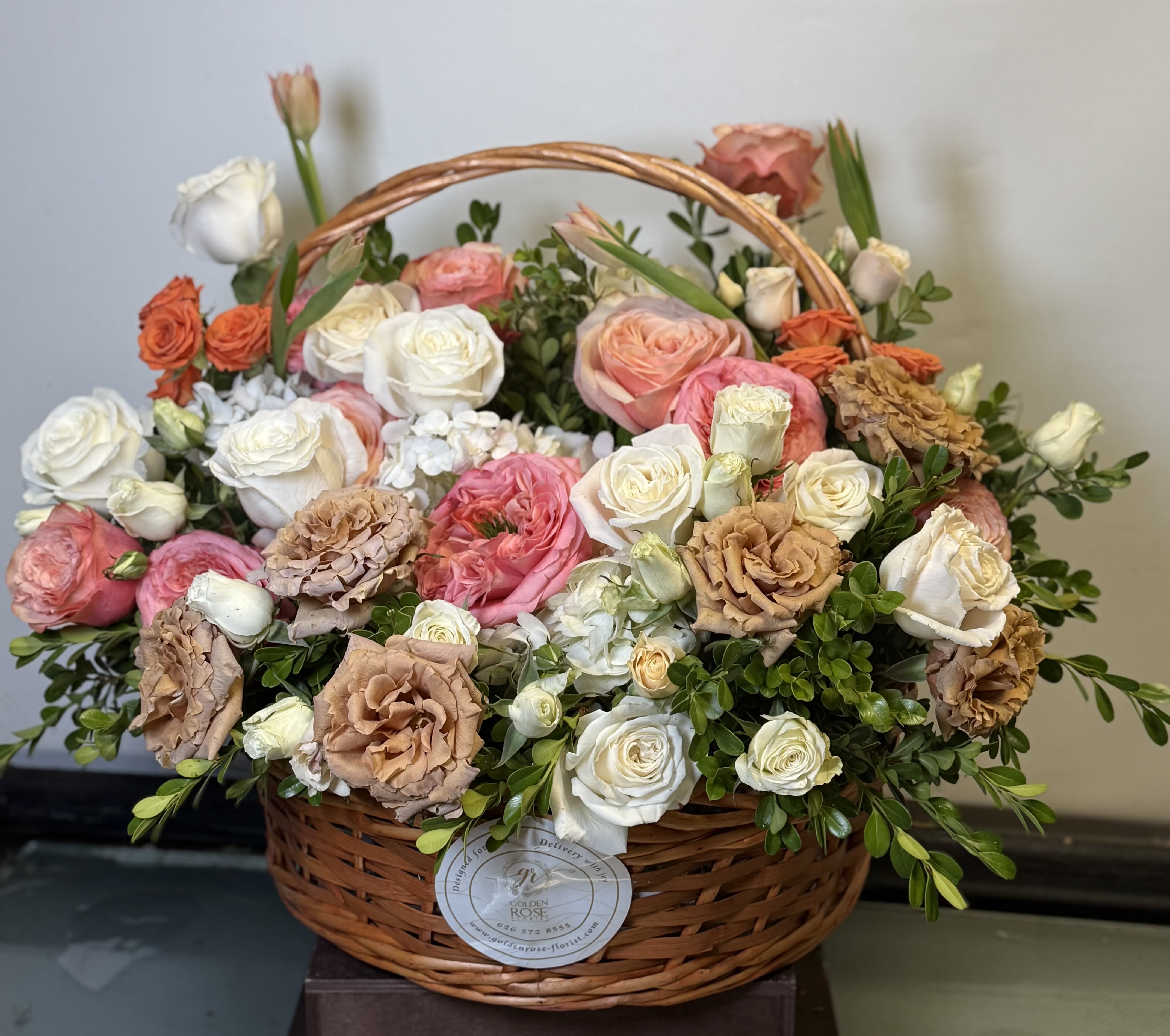 Sunset Elegance Basket  - Premium floral basket featuring white roses, garden roses, lisianthus, and soft peach, salmon, and coral accents. An elegant and lush arrangement for special occasions. Please note: Flower substitutions may occur based on seasonal availability or what we have in stock, but we will always maintain the overall look, color palette, and quality of the design.