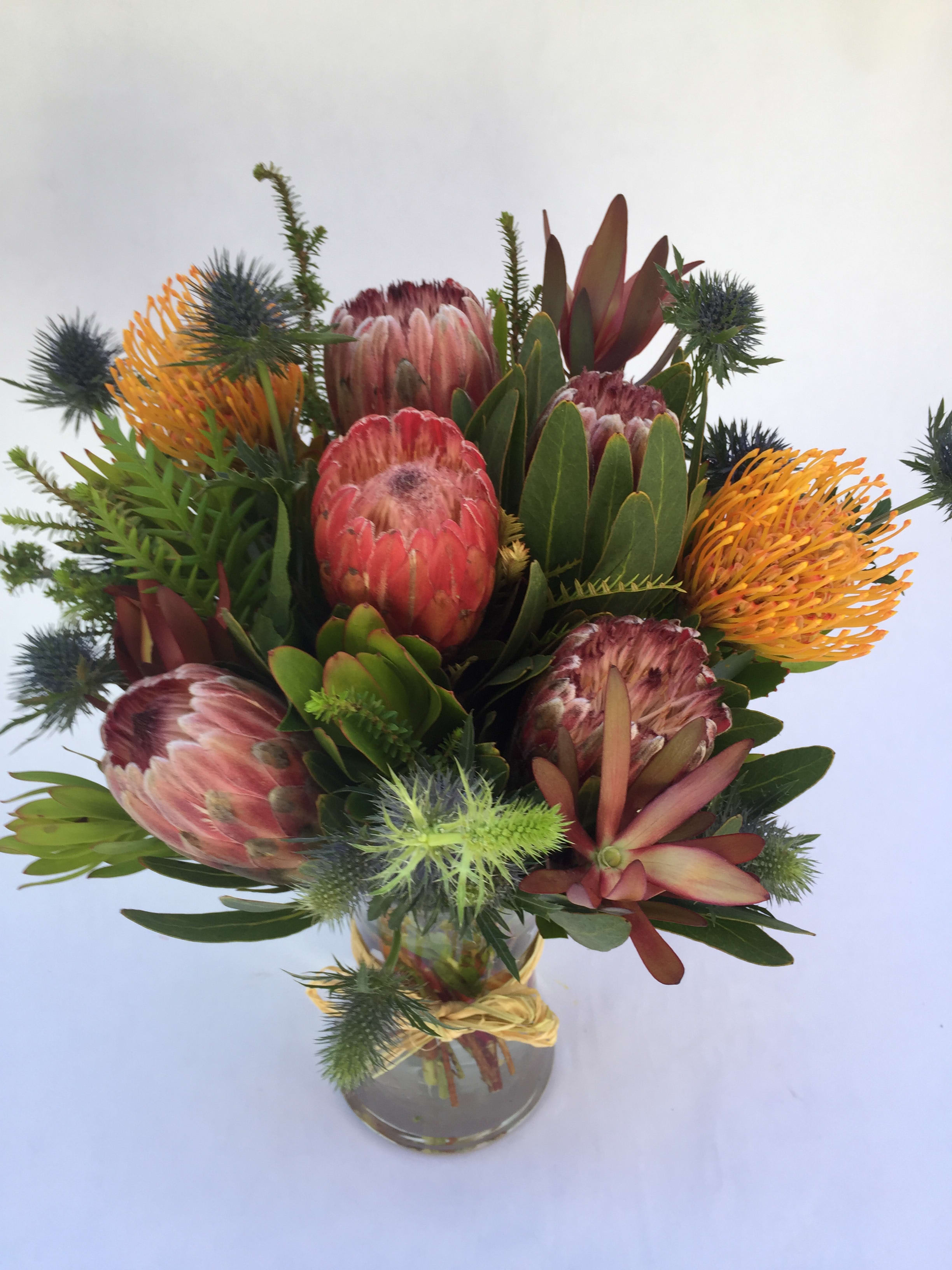Wild &amp; Strong Protea Vase Arrangement. (L0NG LASTING ! ) - A mix of protea, thistle and other long-lasting and strong stems. Unique, funky, and modern look. Arranged in a glass vase.  (Some flowers may be subject to change depending on the season. We will contact you with available flower substitutions; please contact us with specific questions if you are concerned with flower availability, thanks.) Featured Arrangement: 128.75