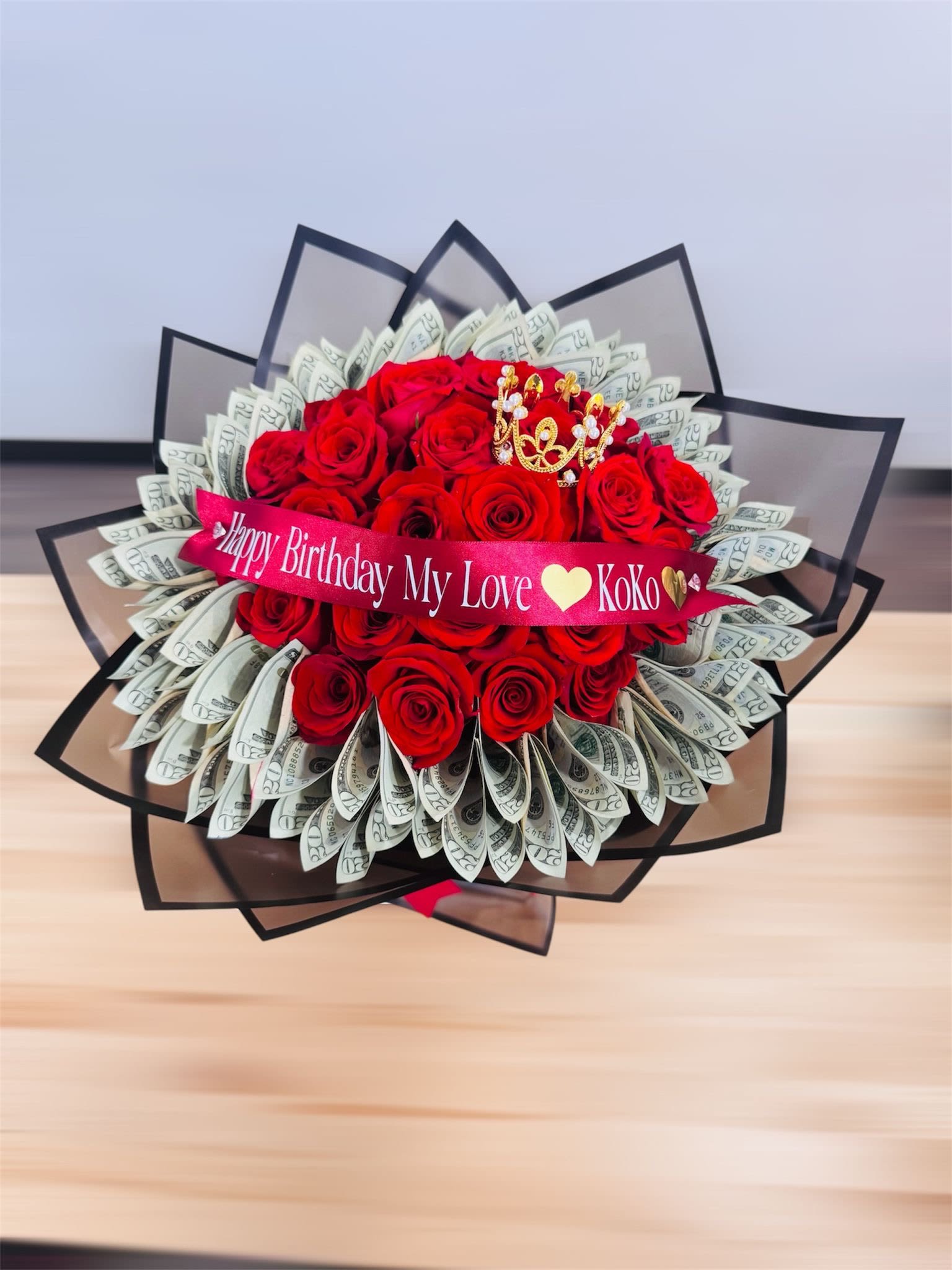 Royal Bloom Royal Bloom - It's a luxurious bouquet of red roses decorated with 1,000 in 20 dollars bills, topped with a golden crown and a silk ribbon with message.