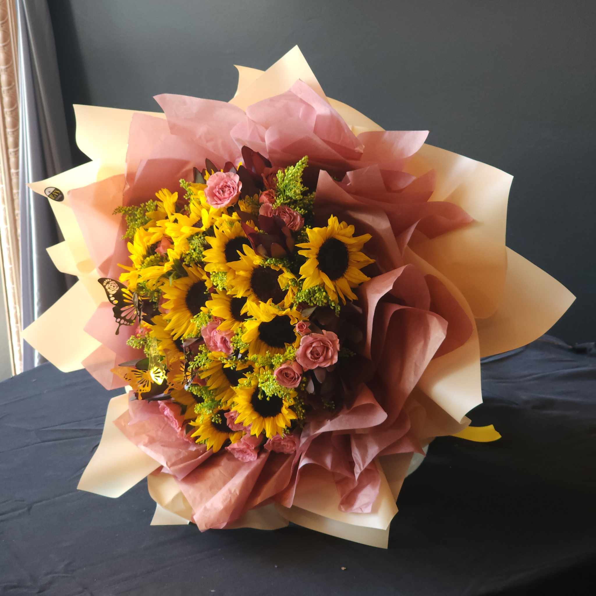 My Sunshine - Who doesn't love sunshine in a wrap. Sunflowers, Safari sunsets, spray roses and pretty filler. Presented in stunning floral paper.