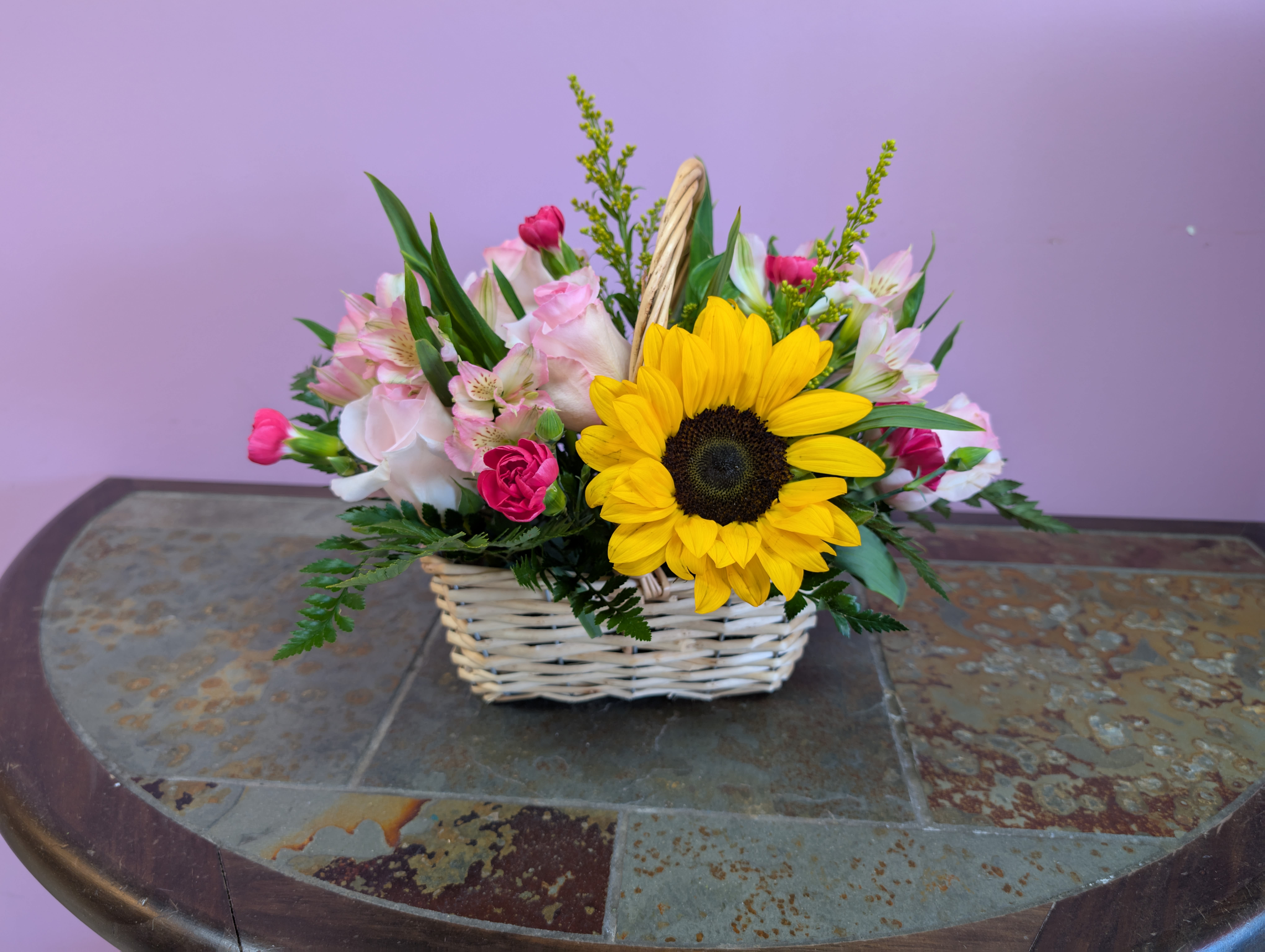 Little Ray of Joy - Bring joy through this tender floral basket than includes: Light pink roses, mini carnations, sunflower and more. 