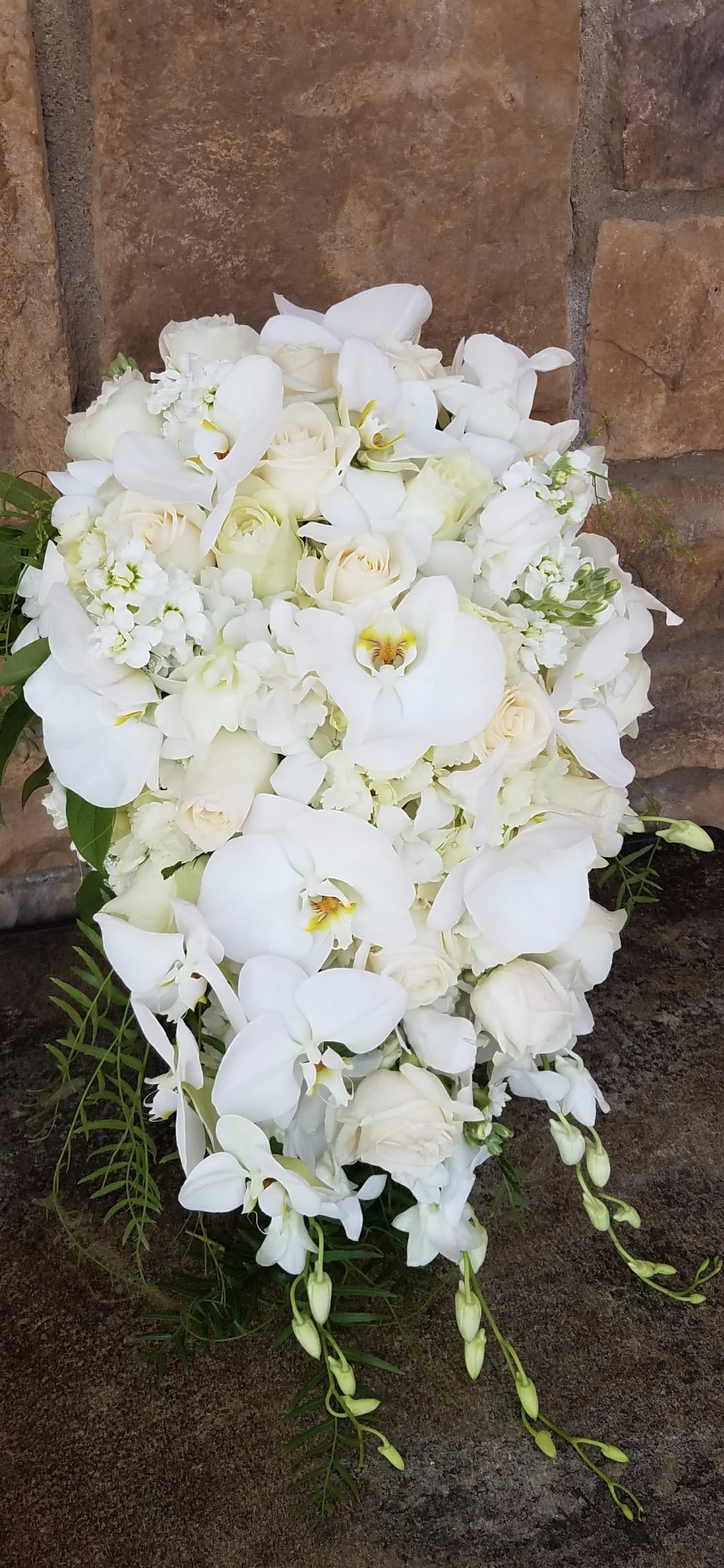 Timeless Purity - Opulent design that will ornate the bride with a dream like bridal bouquet.   This exquisite bridal bouquet is designed with all white specialty flowers to spotlight your very special day. All bridal bouquets include groom's boutinier.  Please note: not all designs are completely identical to each other but never compromising the bride's floral inspiration.