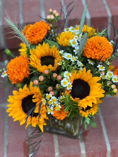 Farmers Harvest Farmers Harvest - Sunflowers and marigolds make up this fall favorite arranged with other textures of berries, wheat, and eucalyptus.