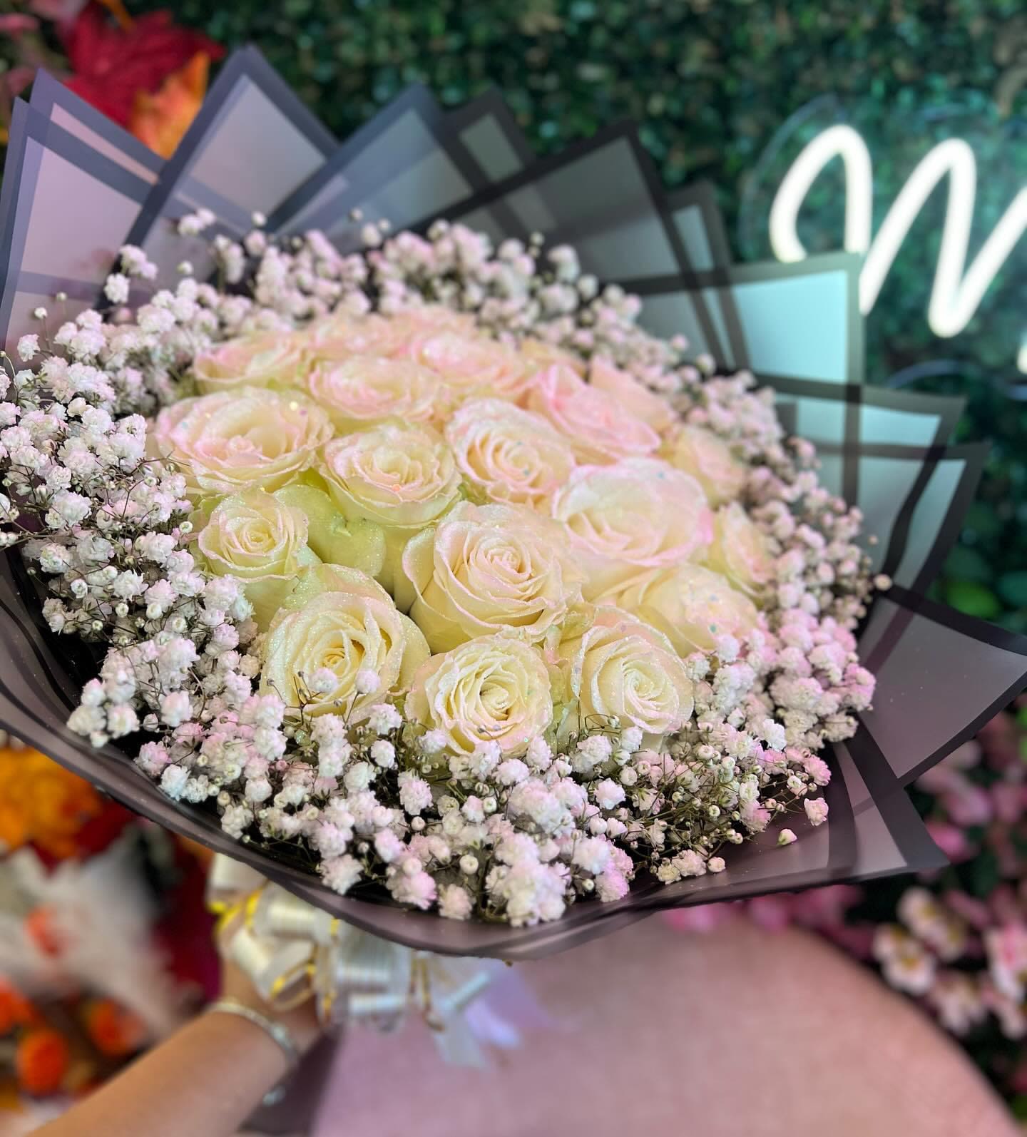 Snowy Bliss - The bouquet is a captivating blend of pristine white roses and delicate sprigs of baby’s breath. This elegant arrangement exudes grace and sophistication, symbolizing purity, innocence, and enduring love. The gentle contrast between the full, velvety petals of the roses and the airy, cloud-like clusters of baby’s breath creates a harmonious and timeless look. Perfect for weddings, anniversaries, or as a heartfelt gift to show admiration and devotion, this bouquet adds an understated touch of luxury and serenity to any occasion. The bouquet embodies the essence of elegance and the simplicity of nature’s finest blooms. STANDARD 25 ROSES DELUXE 36 ROSES PREMIUM 50 ROSES