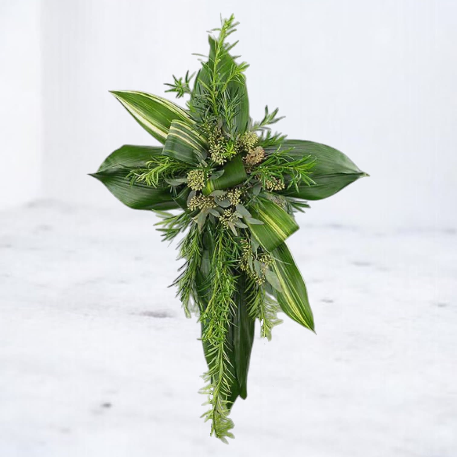 Evergreen Faith Cross - The Evergreen Faith Cross is a timeless expression of faith and remembrance, beautifully crafted with layers of verdant greenery, including eucalyptus, aspidistra, and rosemary sprigs. Its minimalist yet striking design symbolizes enduring love and peace, offering a heartfelt tribute for memorial services. This all-green standing cross radiates natural beauty, making it a thoughtful choice to honor a life filled with faith and grace.  All floral crosses come with easels included for seamless presentation at memorials or services. 