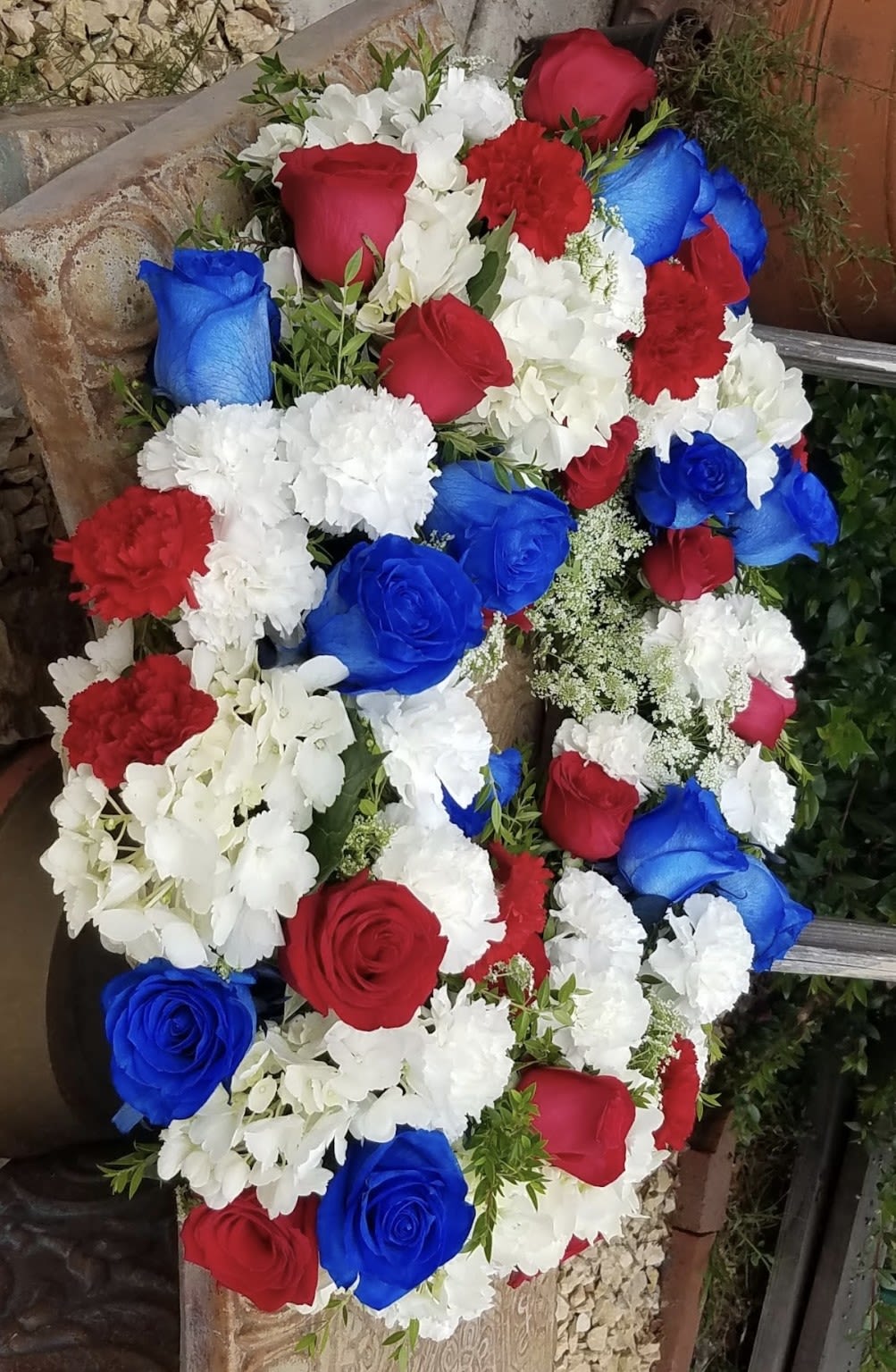 Honoring a Legacy  - A celebratory wreath that includes an easel stand and a personalized ribbon.  Specially designed with the perfect patriotic colors and flowers.
