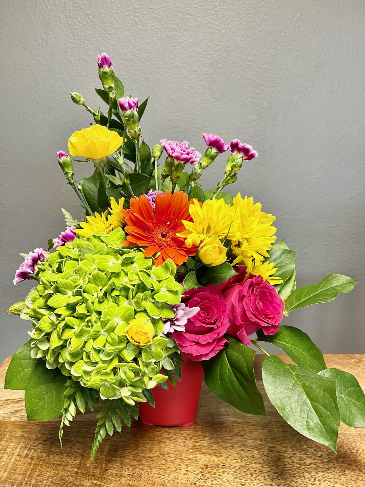 Sunshine Bright - A bright arrangement with pink, green, yellow, orange flowers designed in a bright colored vase. 