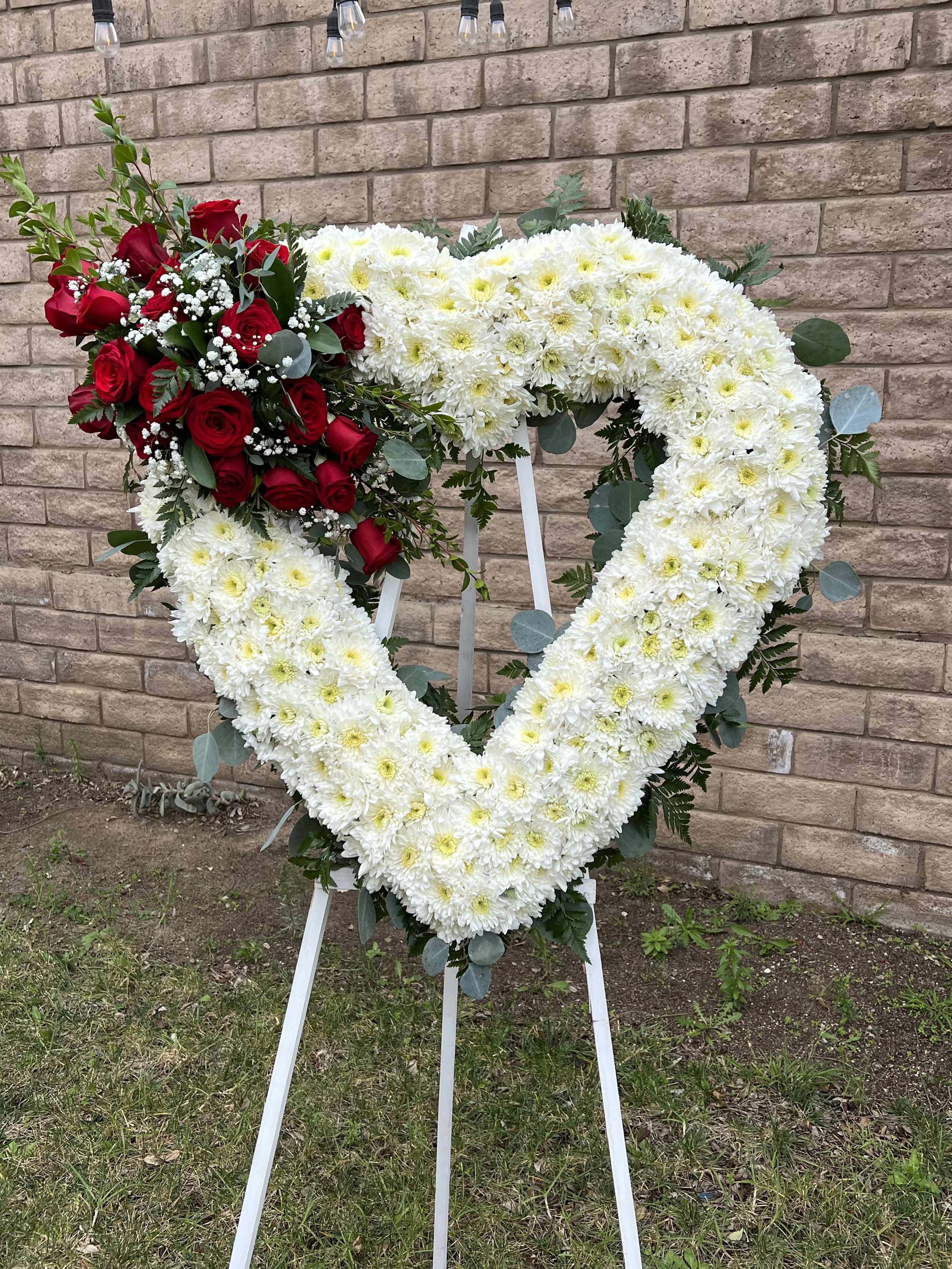 Heart Wreath Heart Wreath - Our Flower Heart Wreath is thoughtfully handcrafted with fresh, seasonal blooms arranged in a graceful heart shape. designed to convey deep affection, sympathy, or celebration of life, this elegant wreath blends soft florals and lush greenery for a heartfelt tribute. Ideal to express your condolences.