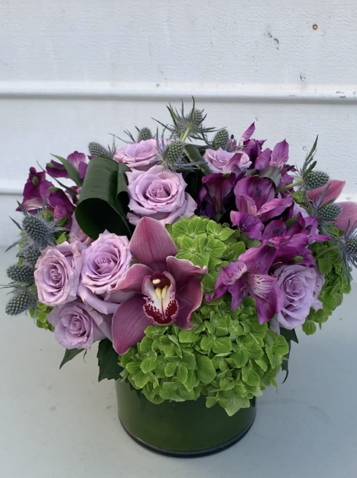 Lavender Mint Lavender Mint - A refreshing bust of lavender and mint, creating a harmonious blend of floral and green hydrangeas in the cylinder glass, 6x6 in. leaf lined.