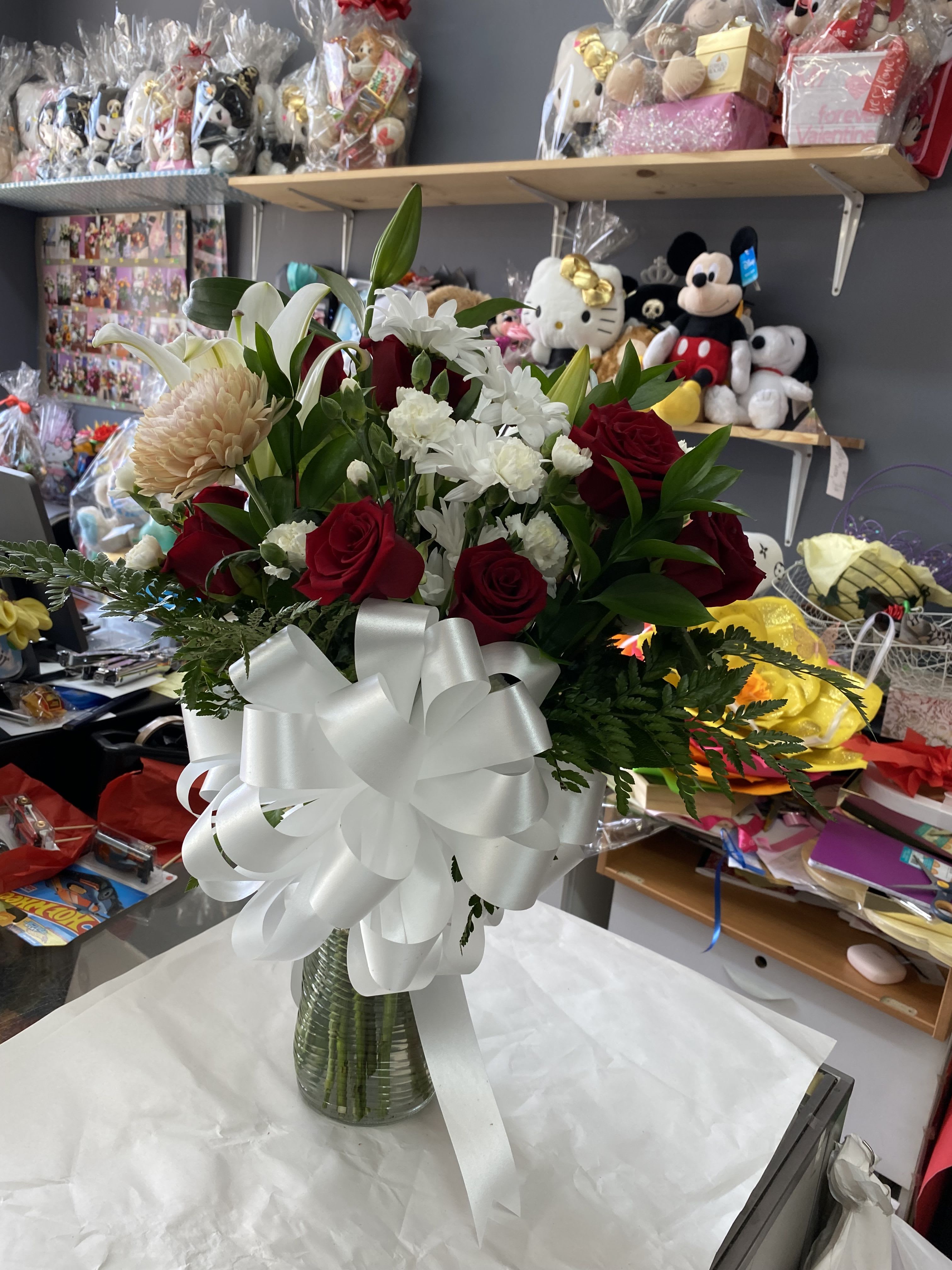 Red roses, lilies, and Cremosos In a vase - It’s an arrangement in a vase,with red roses and a white lily and cremosos