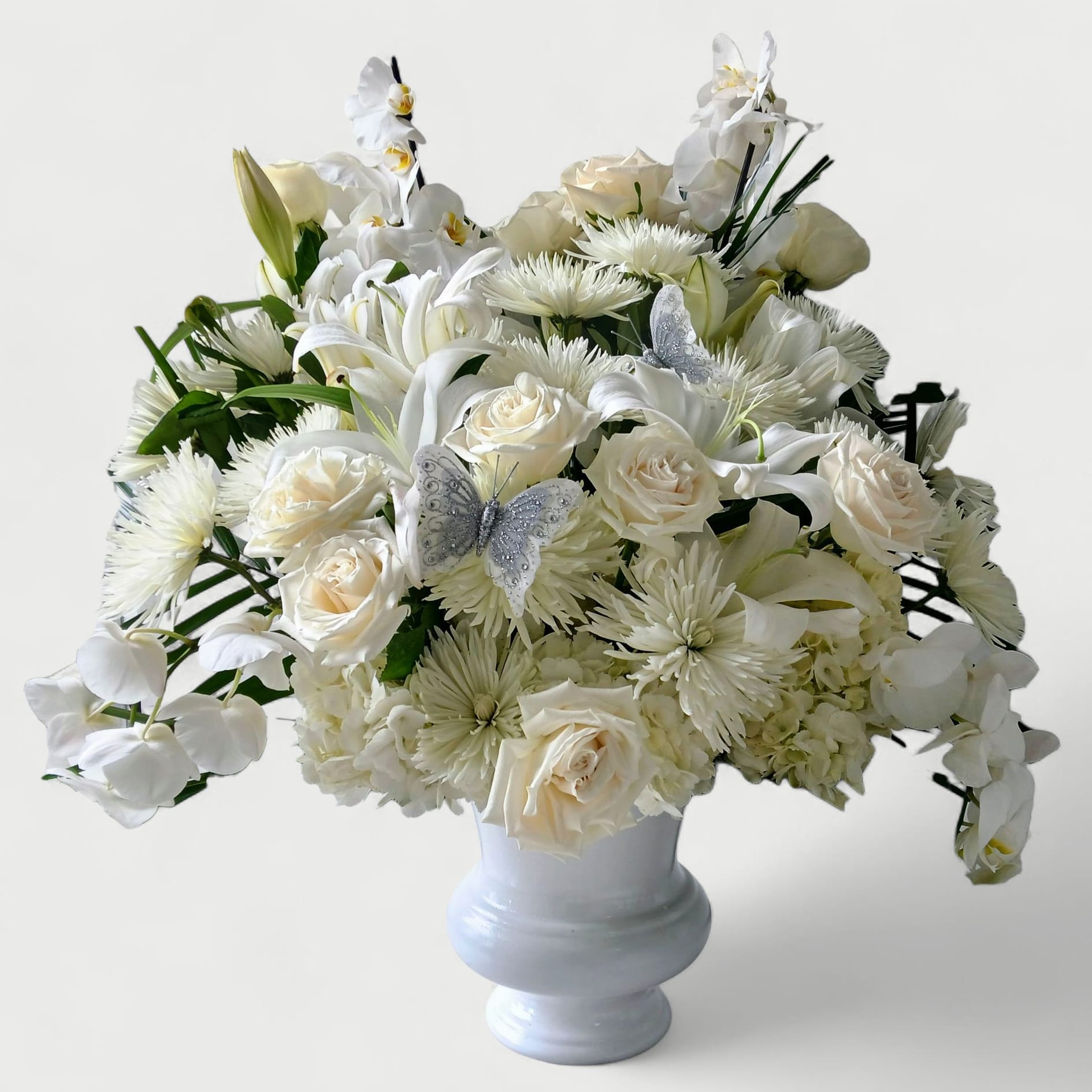 With Loving Memory Condolence Bouquet - Beautiful all white blossoms roses hydrangeas orchids and more arranged in a tall modern white vessel. Perfect for the service to show them how much you care. 